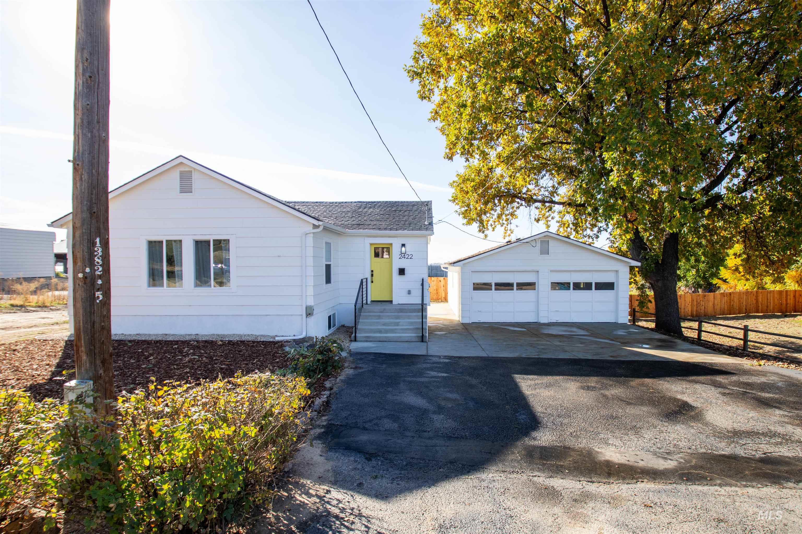 View of front of home featuring a garage and an outdoor structure