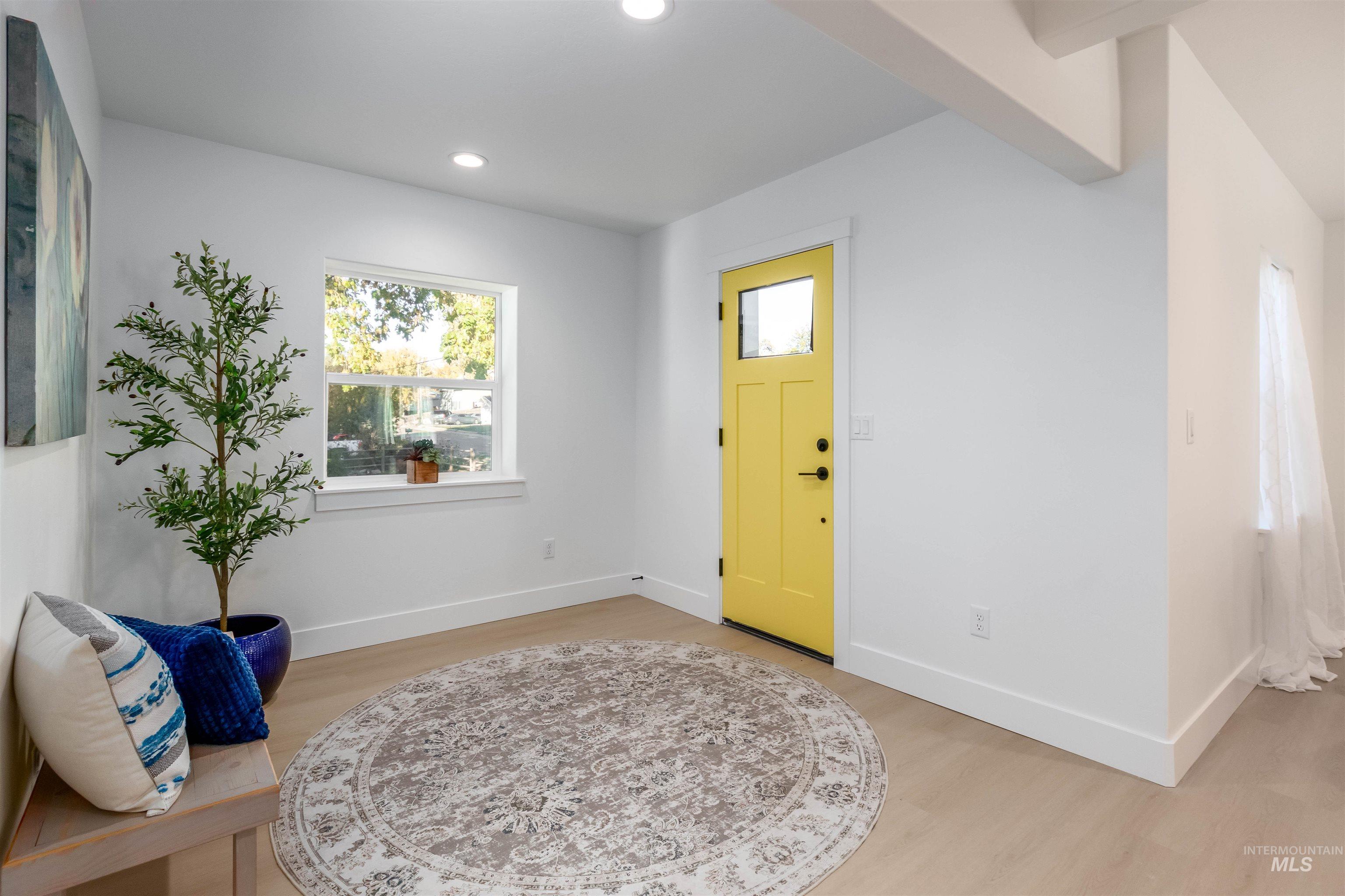Entrance foyer with recessed lighting, light wood-type flooring, and beamed ceiling
