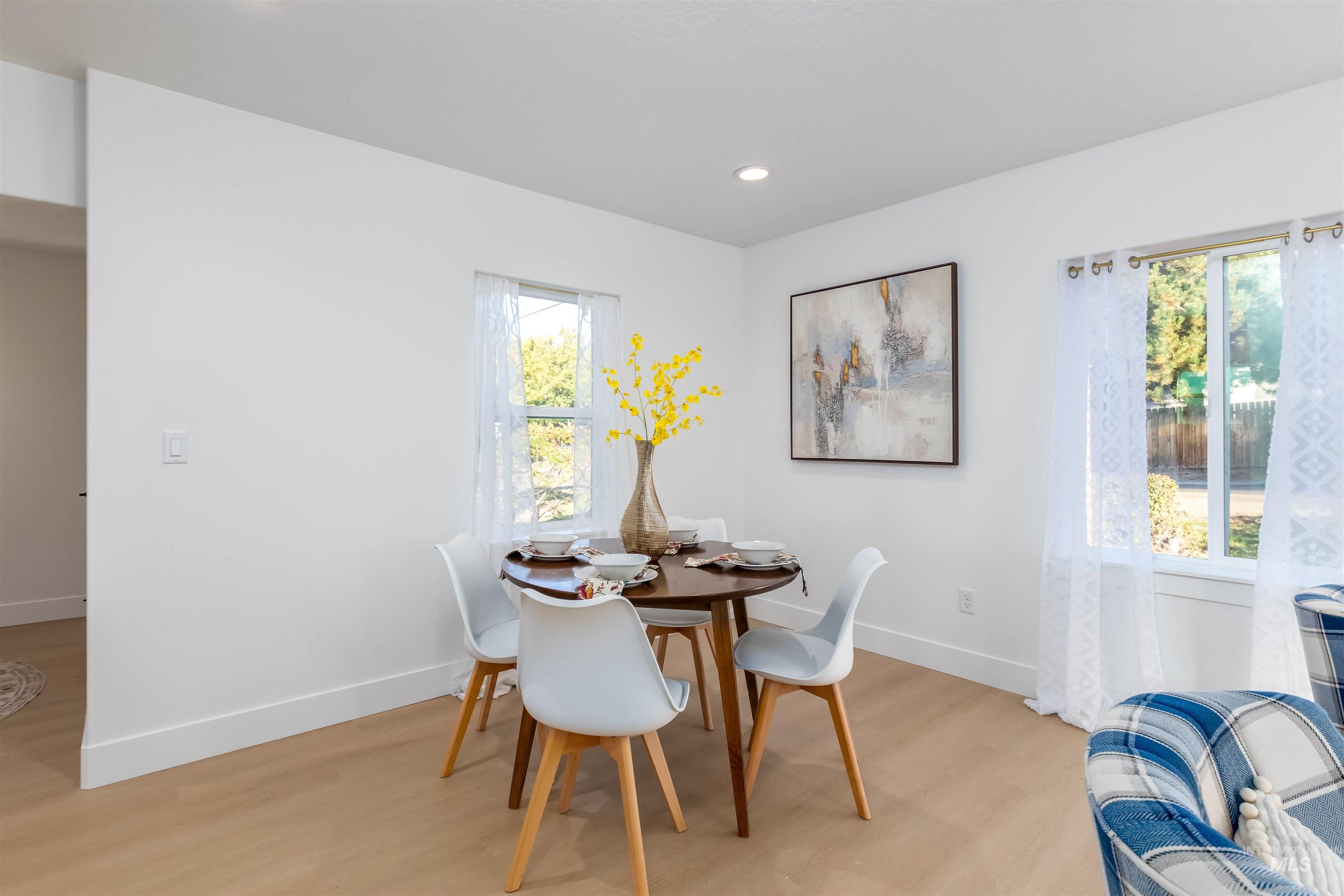 Dining room with light wood finished floors and recessed lighting
