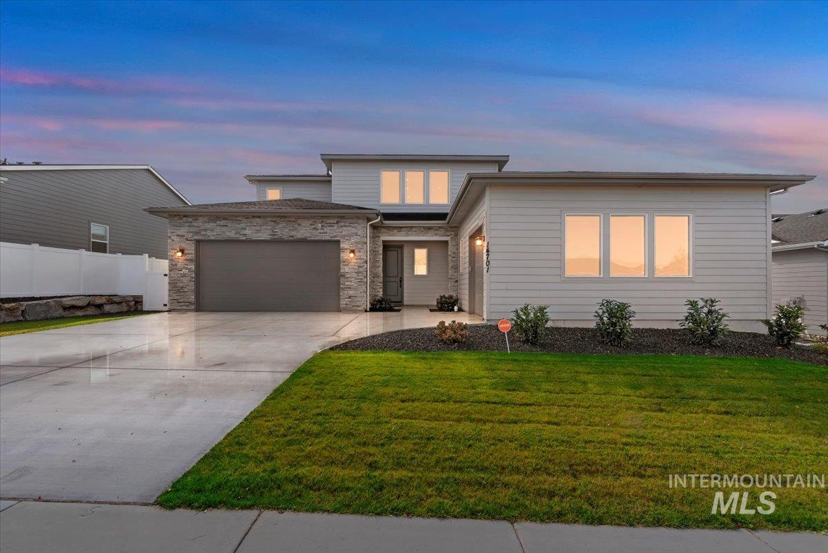 View of front of house with concrete driveway and a garage