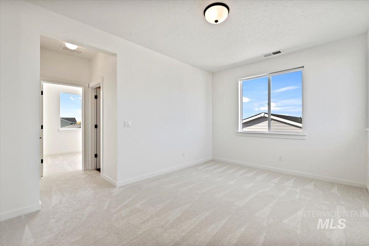 Empty room featuring light carpet and baseboards