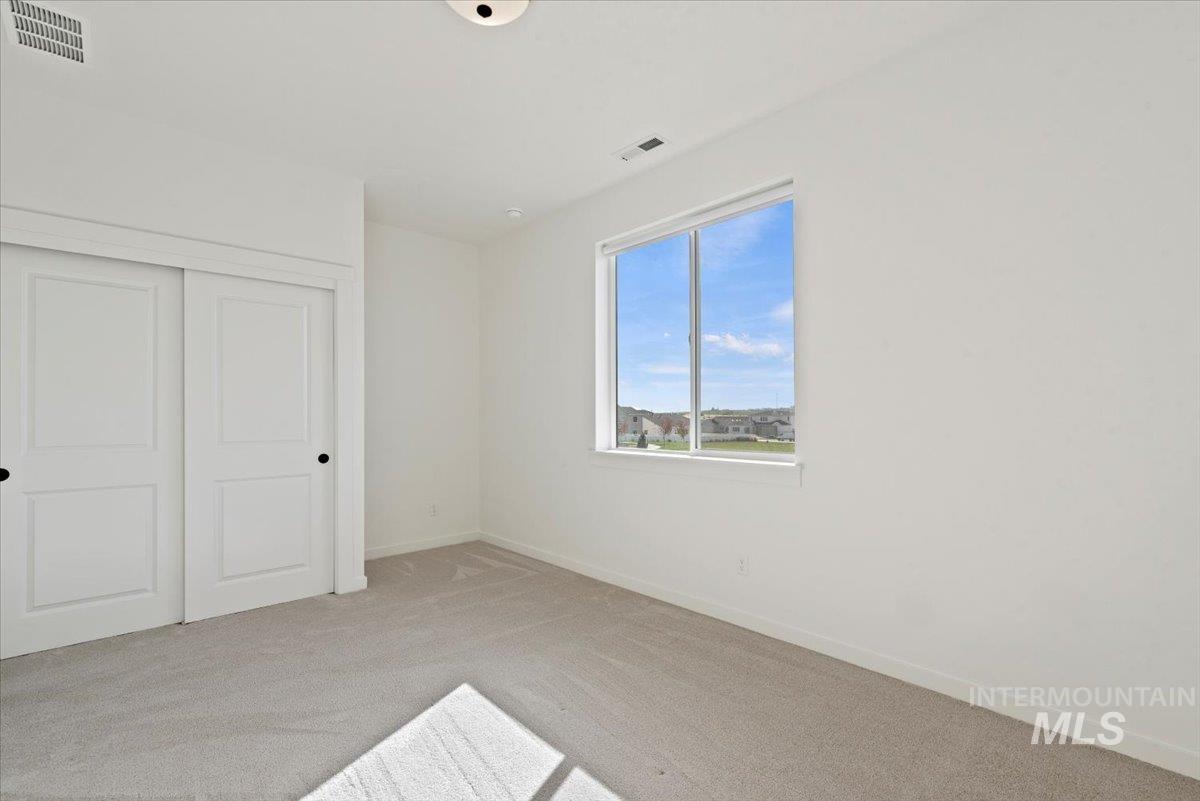 Unfurnished bedroom featuring light colored carpet and a closet