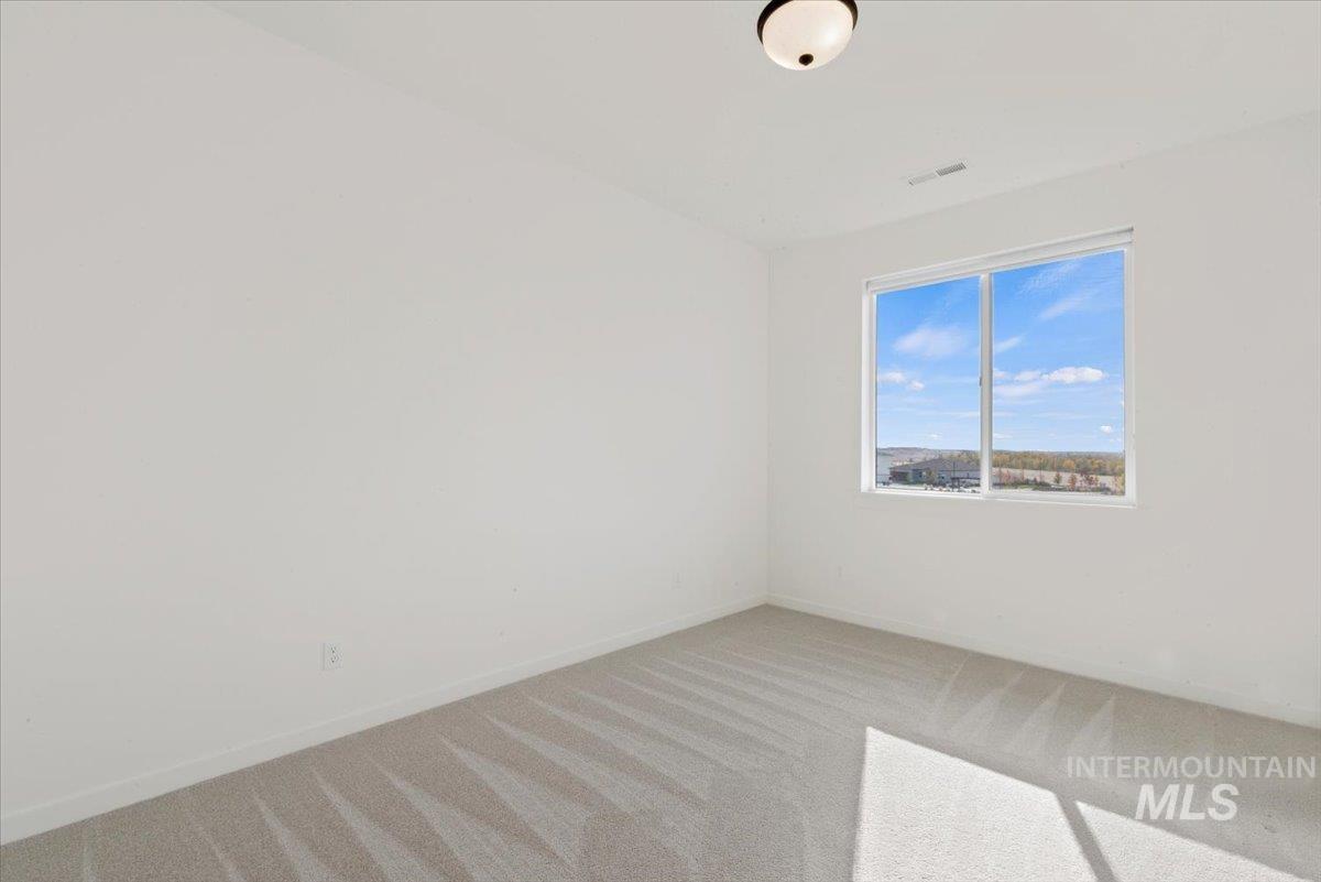 Carpeted spare room with baseboards
