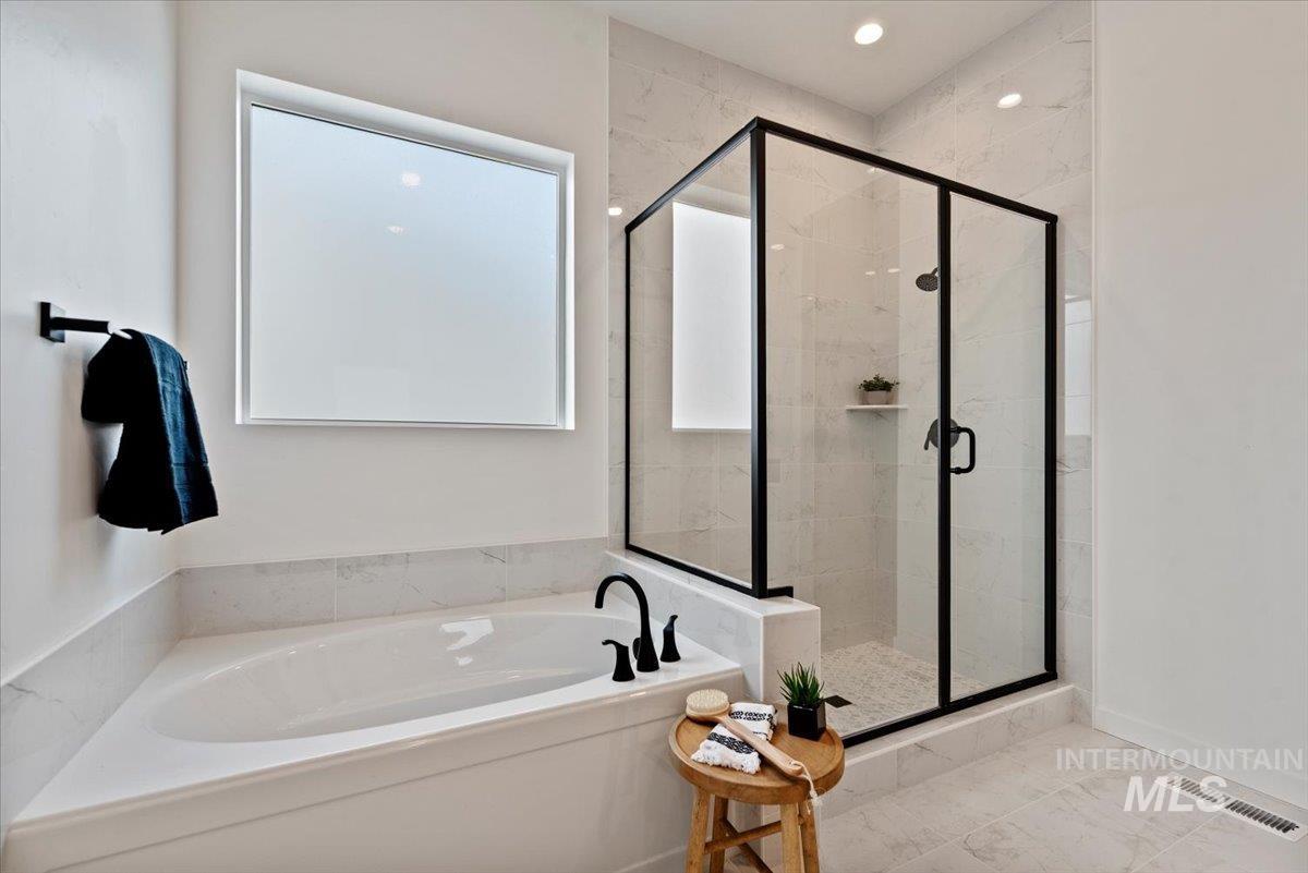 Bathroom featuring a garden tub and a stall shower