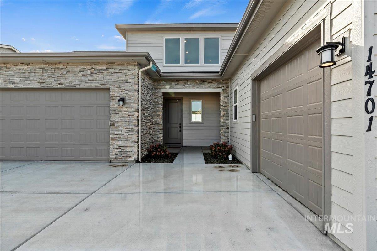 Property entrance featuring stone siding and driveway