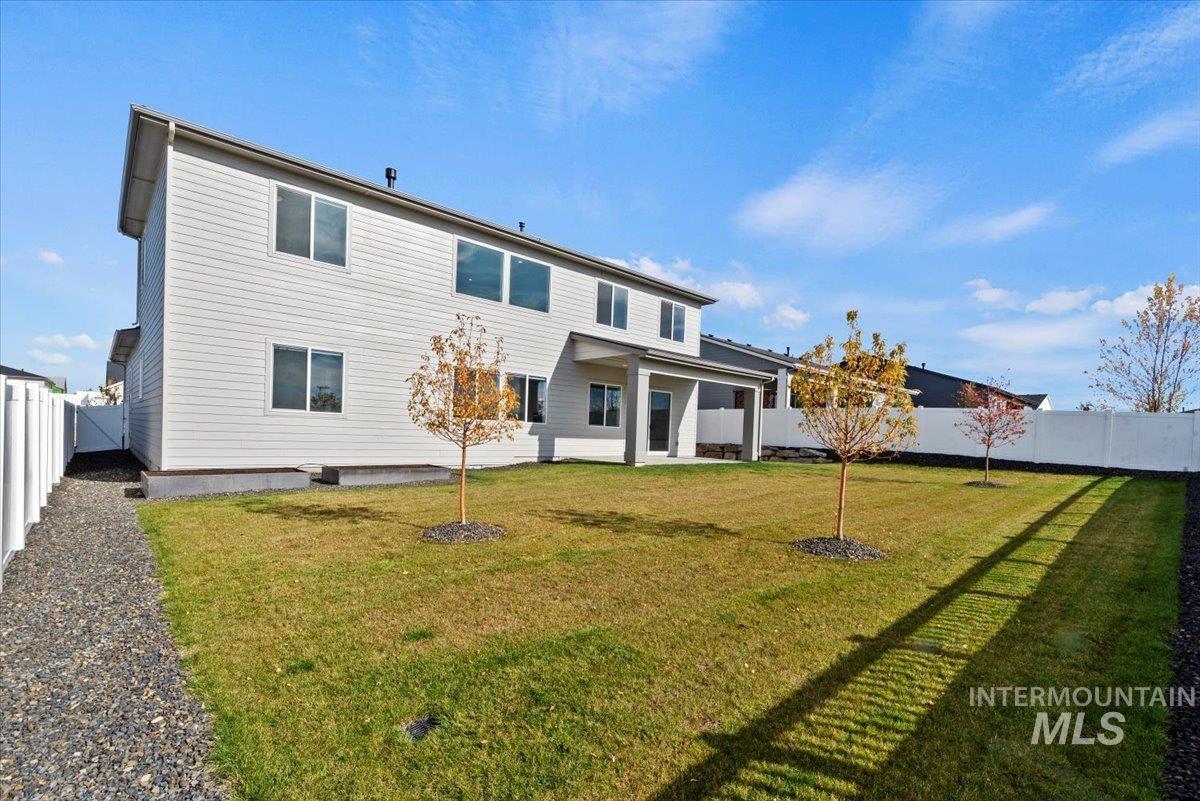 Back of property with a fenced backyard and a patio