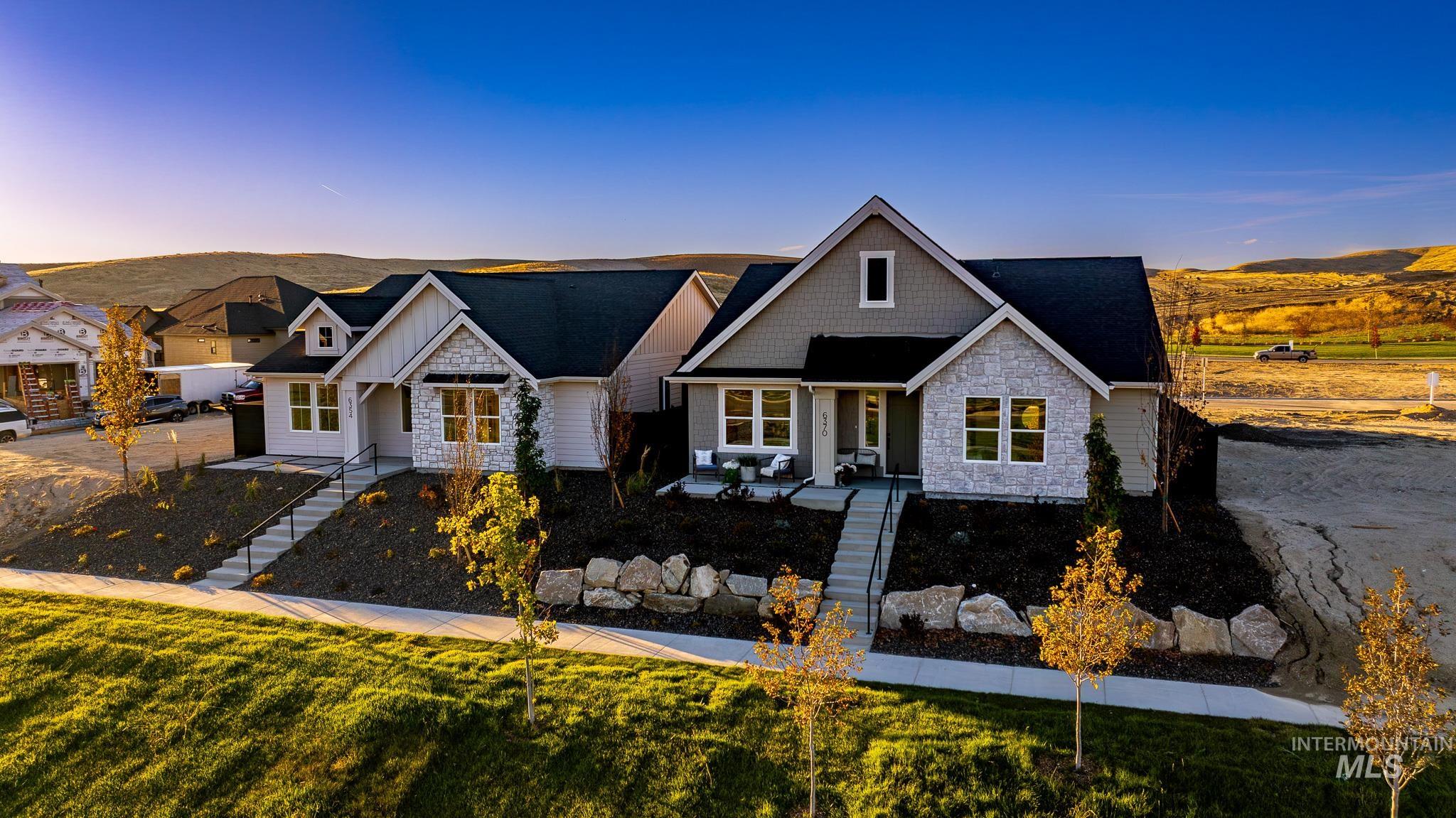 View of front of house with stairway, stone siding, a porch, and board and batten siding