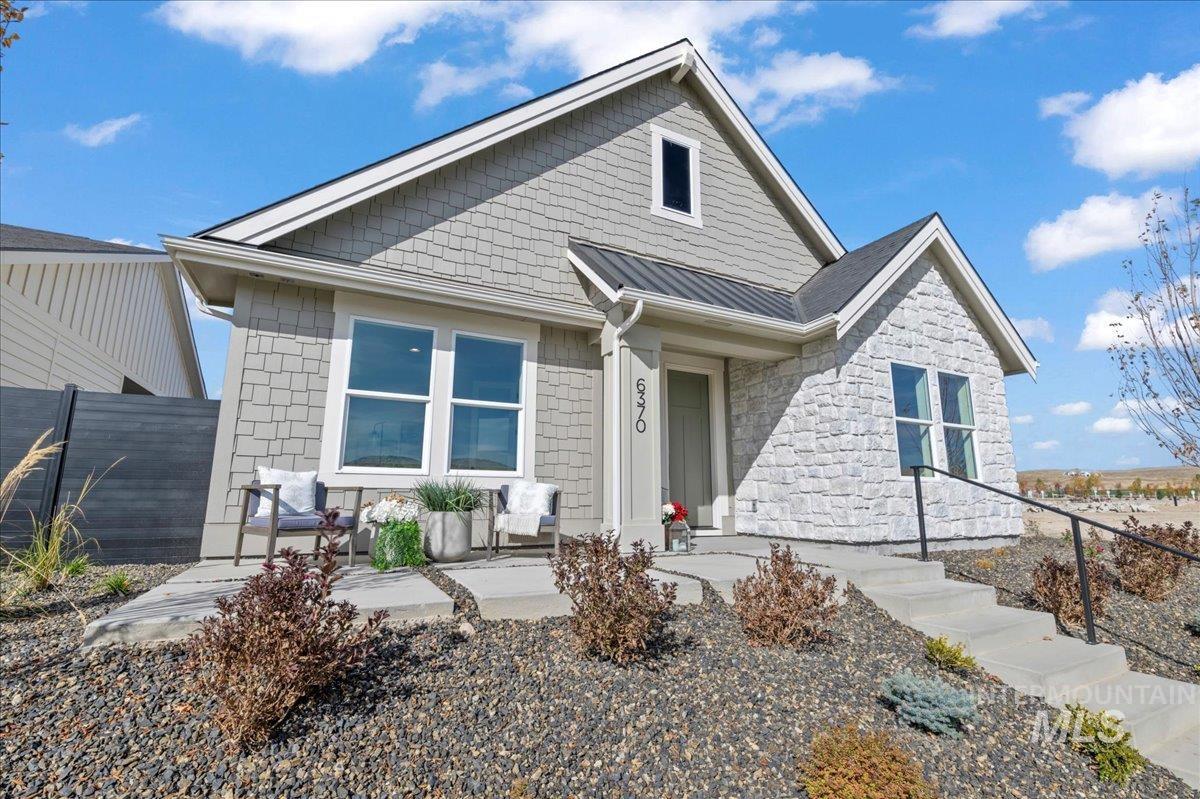 View of front of home featuring a metal roof, stone siding, and a standing seam roof