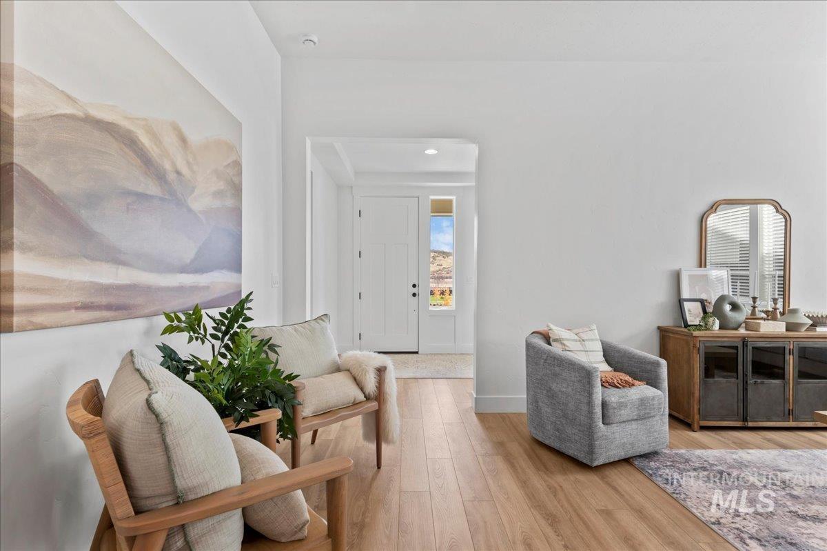 Sitting room with light wood-type flooring and recessed lighting