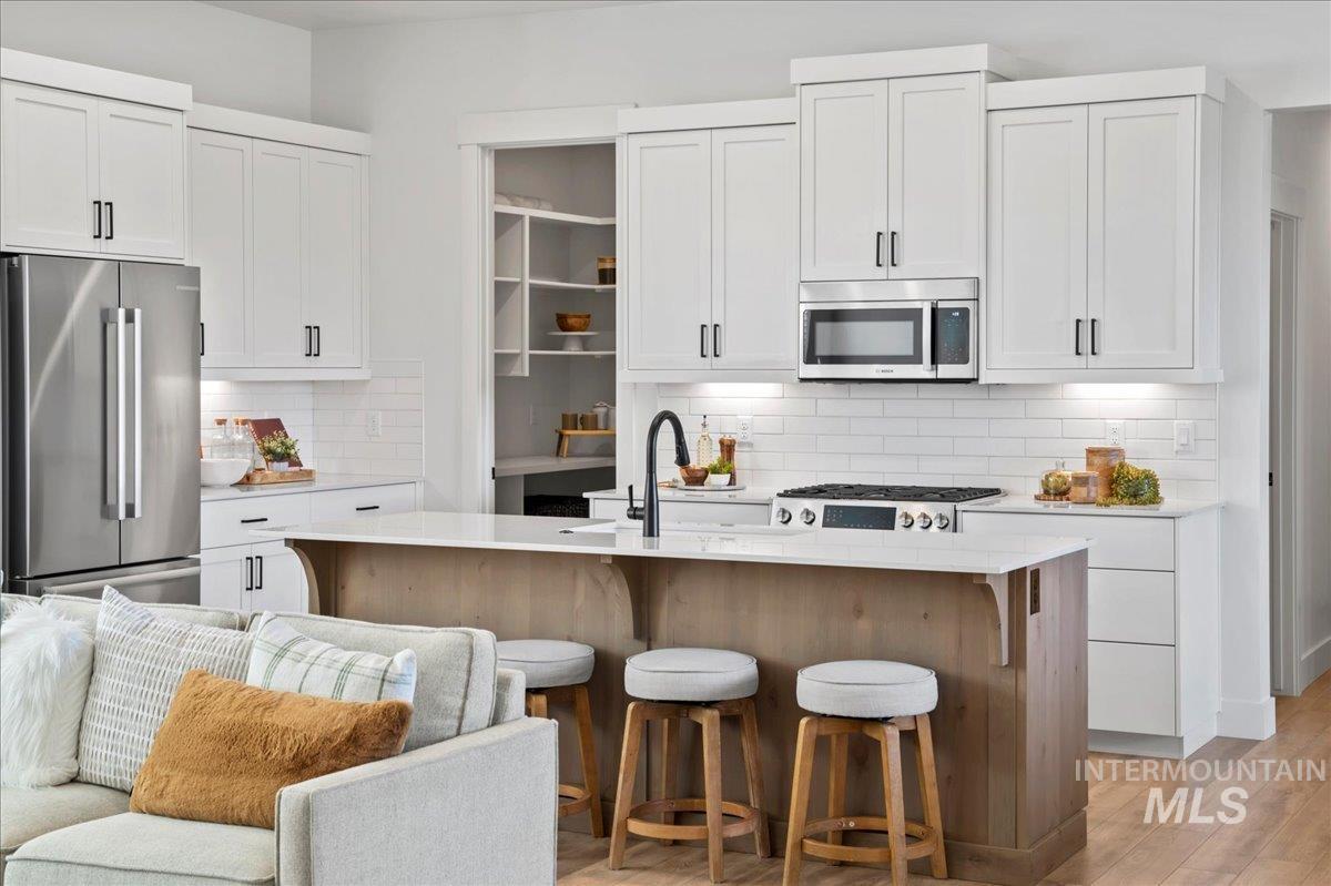 Kitchen featuring stainless steel appliances and white cabinetry
