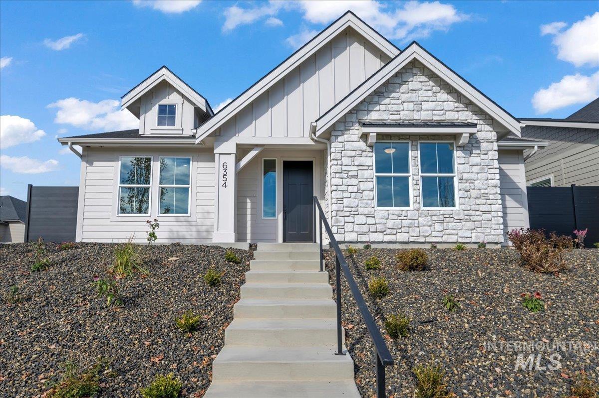 View of front of home featuring stone siding and board and batten siding