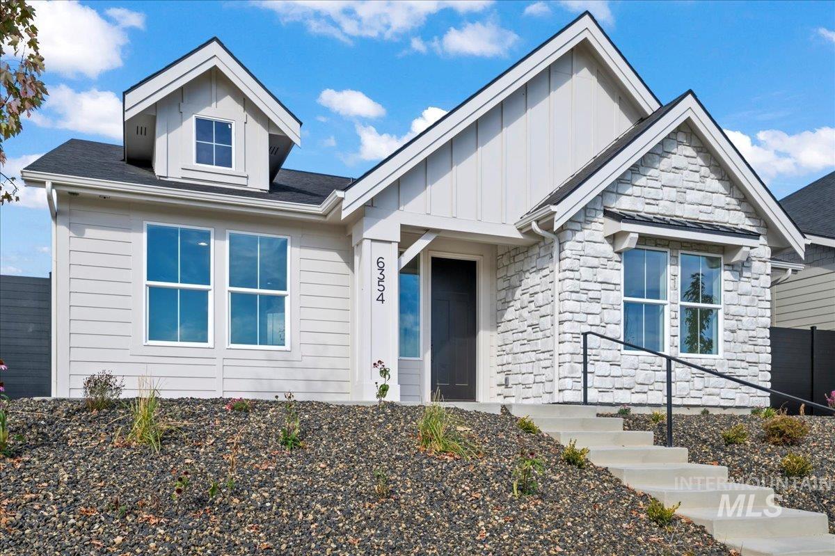 Entrance to property featuring stone siding and board and batten siding