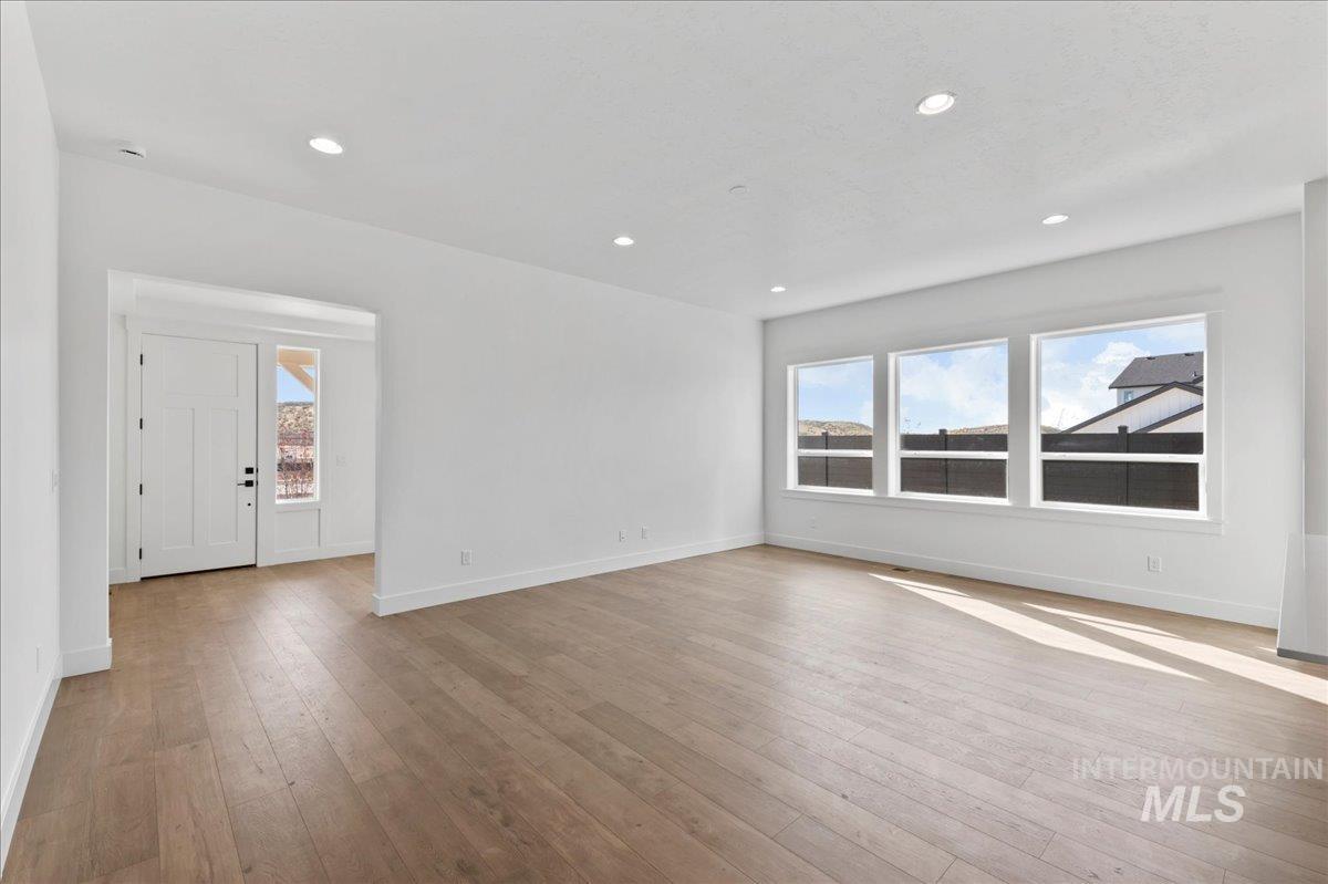 Unfurnished living room featuring healthy amount of natural light, light wood finished floors, and recessed lighting