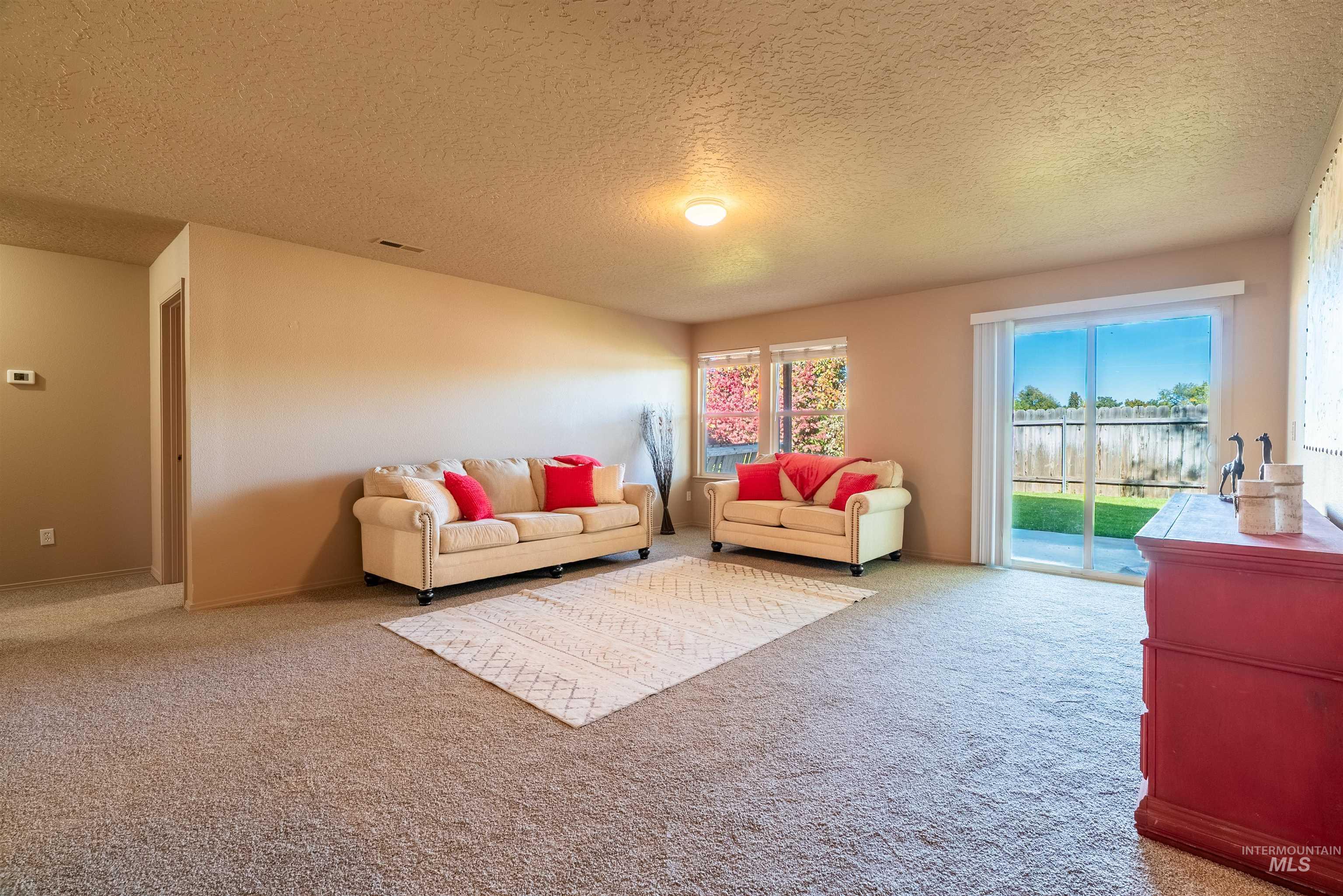 Living area featuring a textured ceiling and carpet
