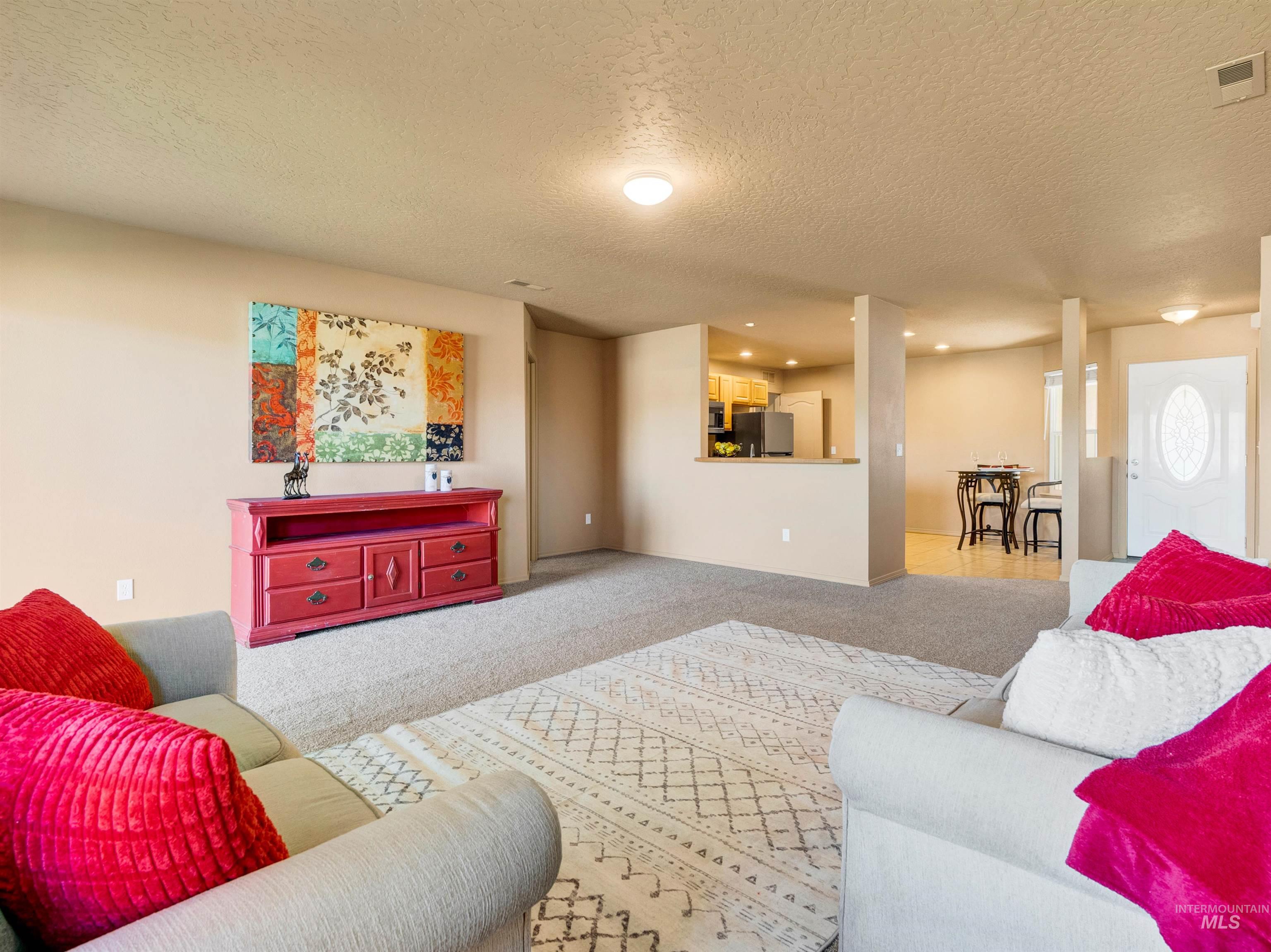 Carpeted living room with a textured ceiling and recessed lighting