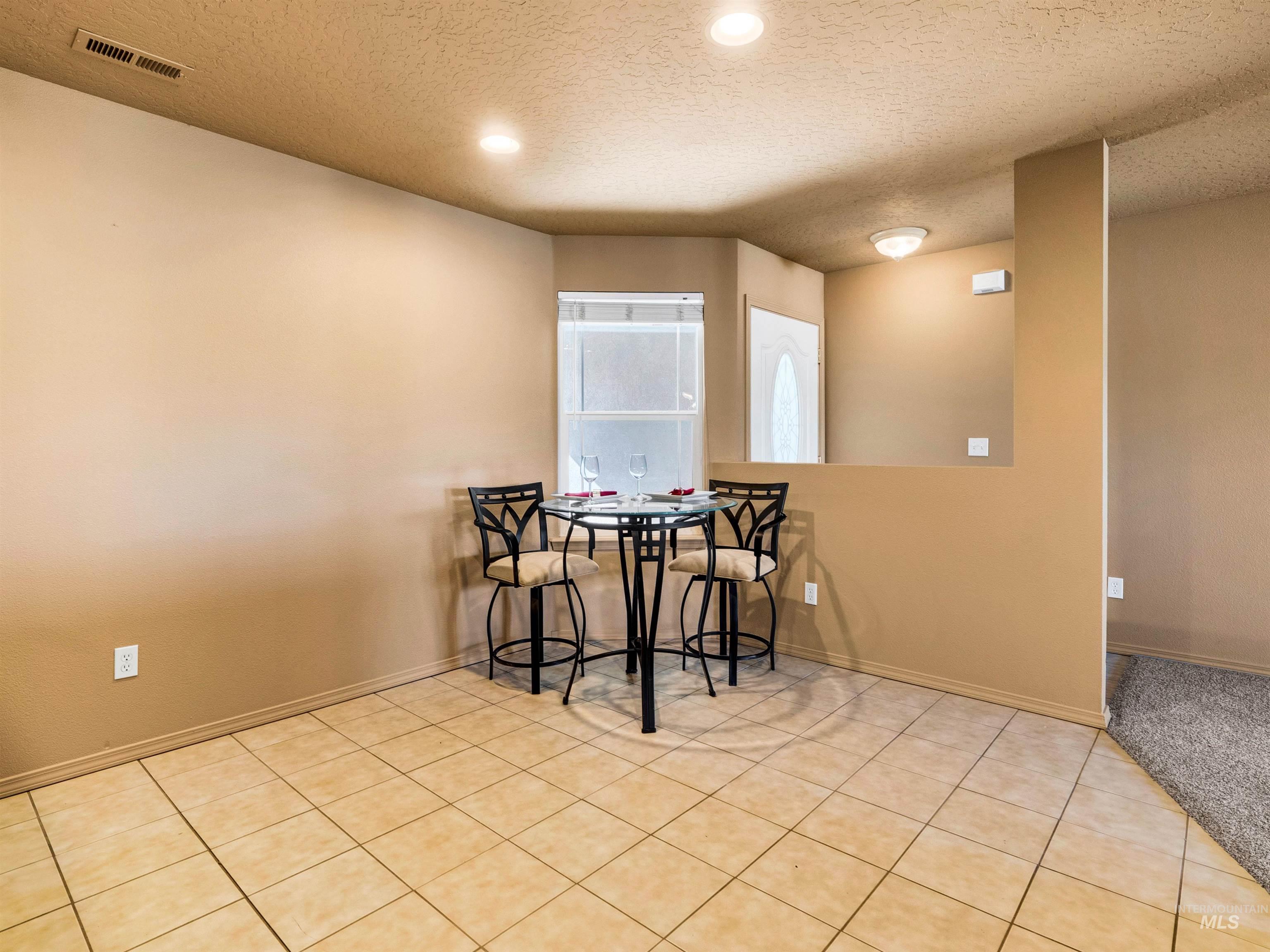 Dining space featuring a textured ceiling, light tile patterned floors, and recessed lighting