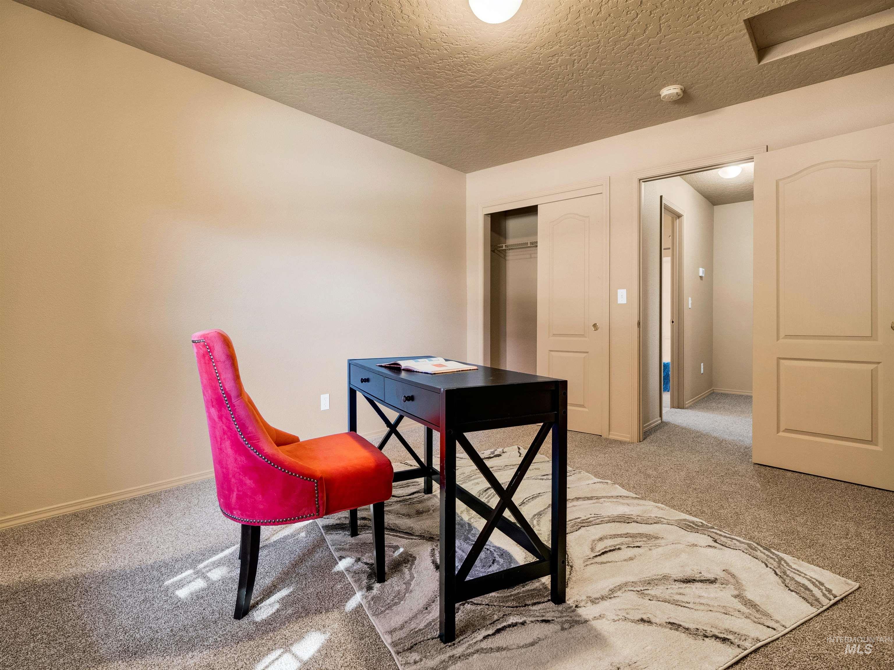 Office featuring light carpet and a textured ceiling