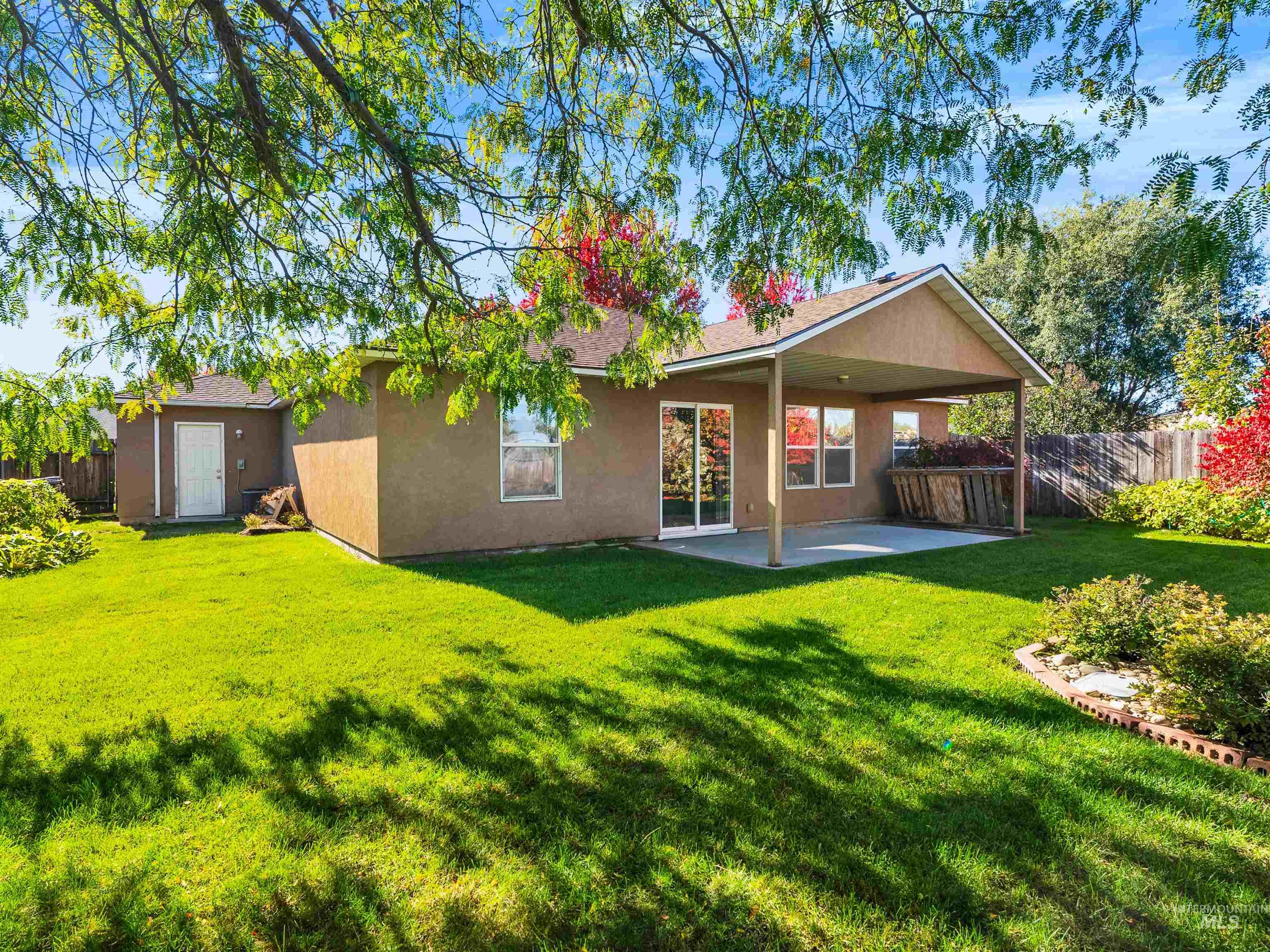Back of property featuring a fenced backyard, a patio area, and stucco siding