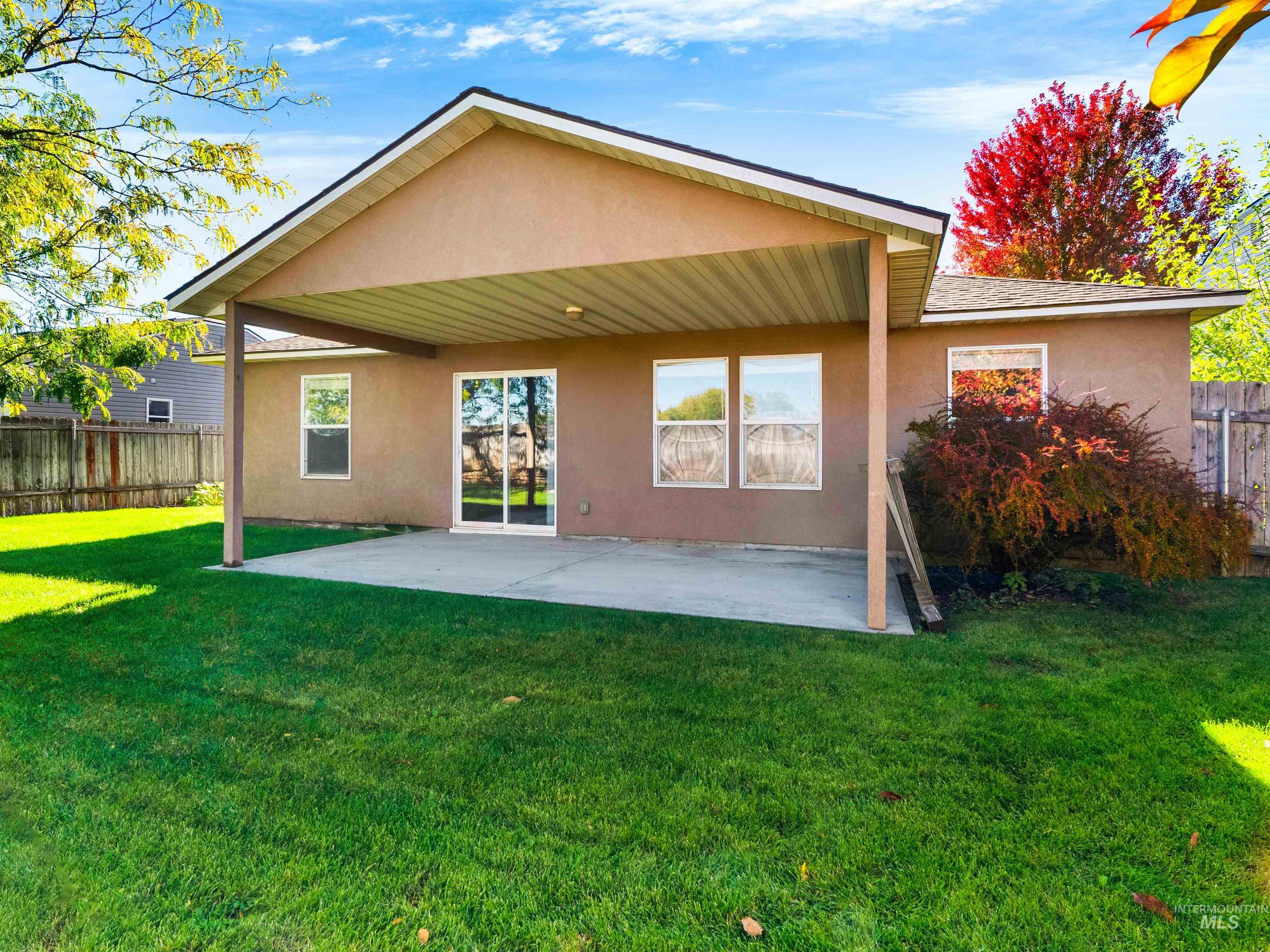Back of house with stucco siding and a patio