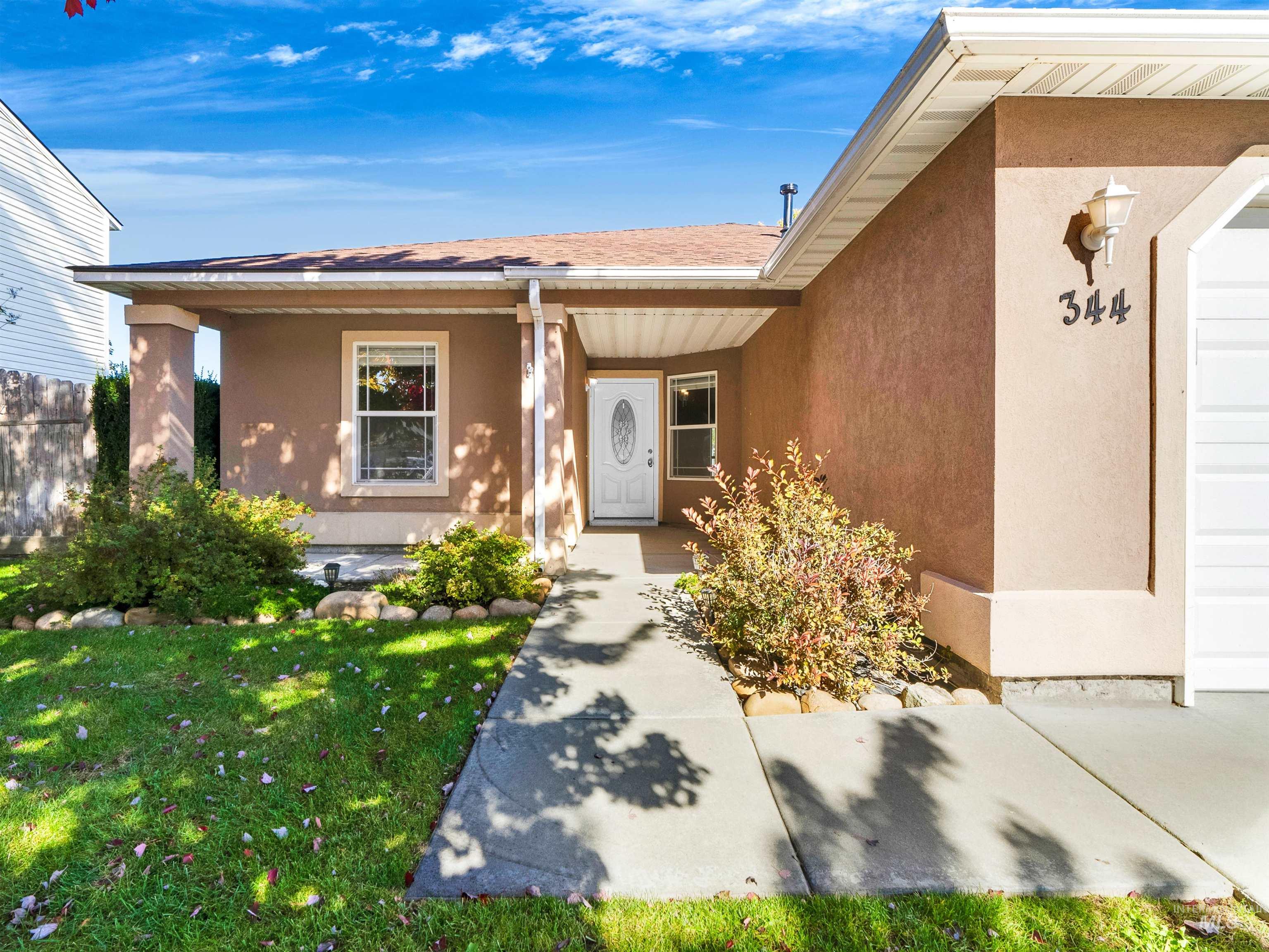 Property entrance with stucco siding, a porch, and roof with shingles