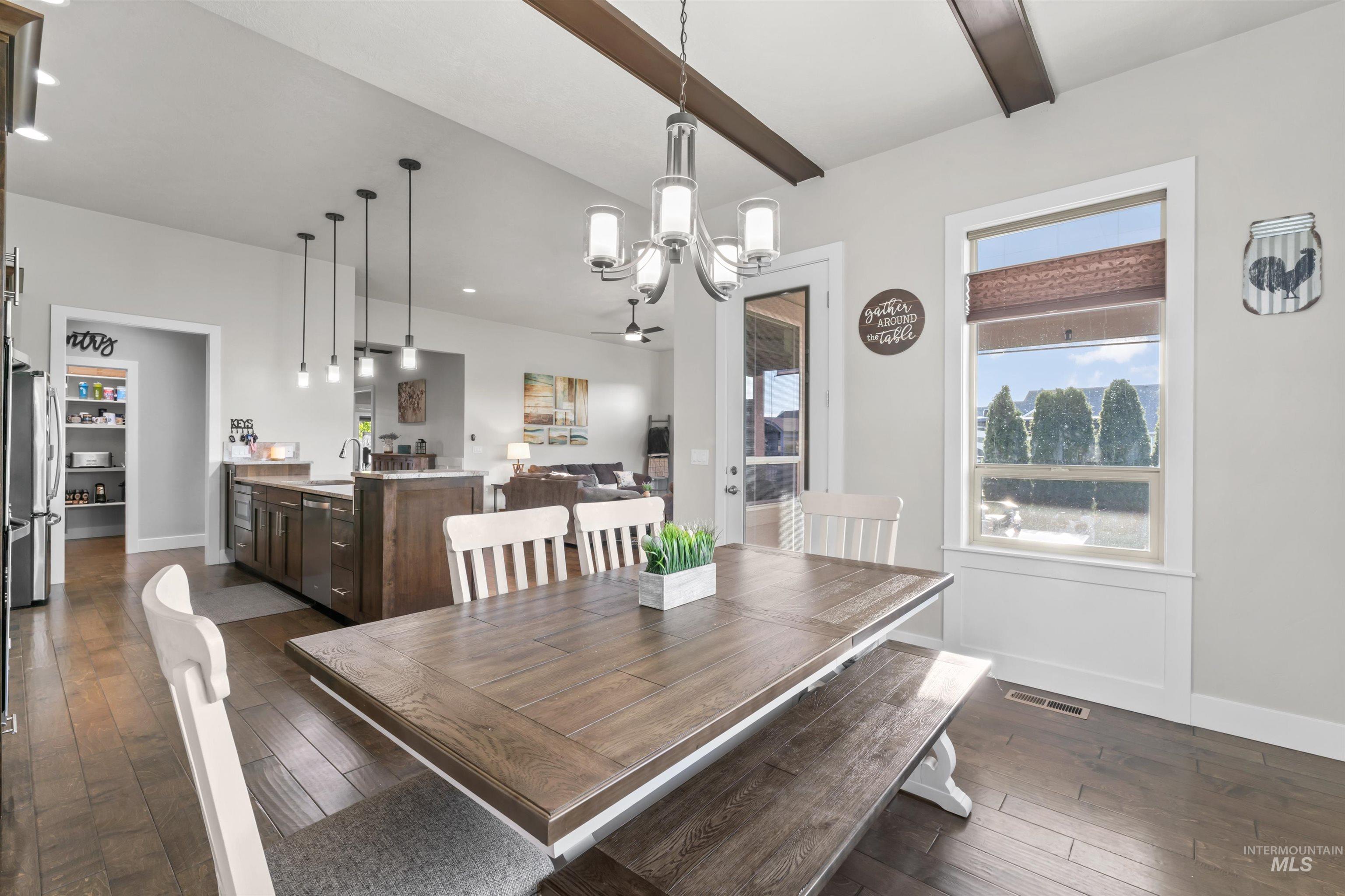 Dining space with a chandelier and dark wood-style flooring