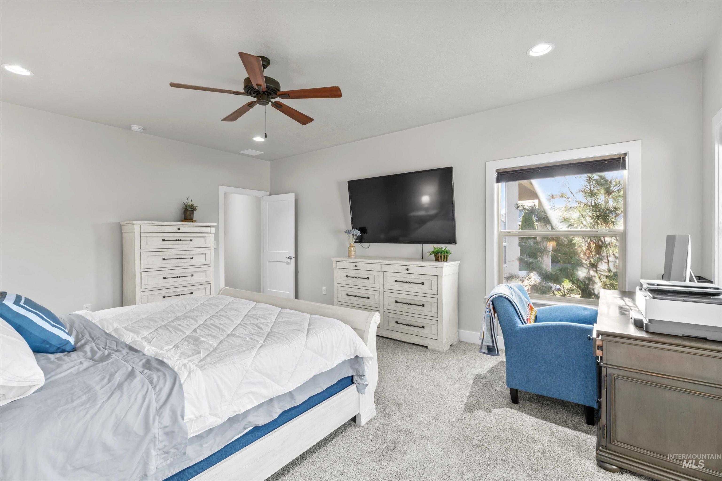 Carpeted bedroom featuring a ceiling fan, recessed lighting, and an office area