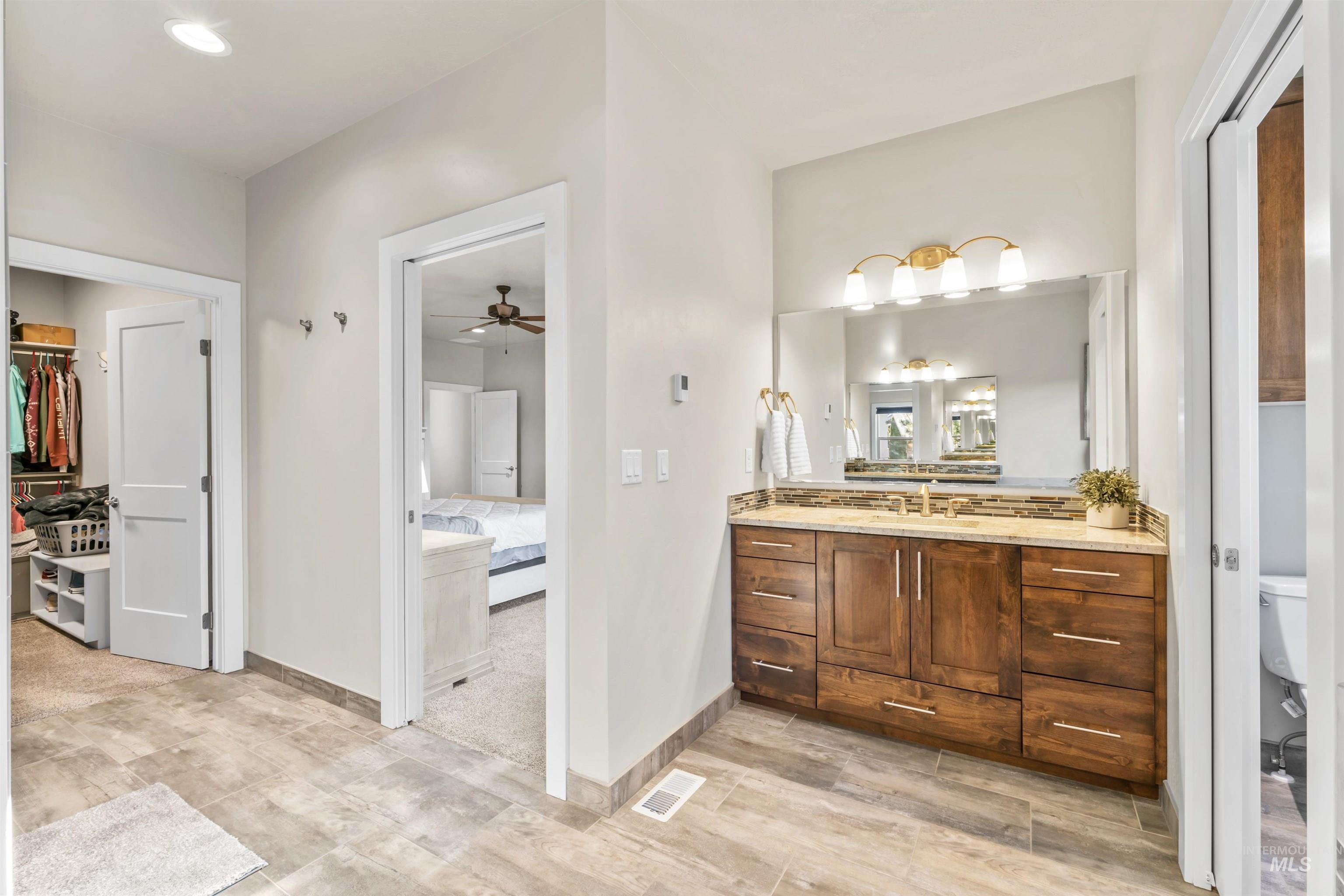 Bathroom featuring vanity, a ceiling fan, recessed lighting, and a walk in closet