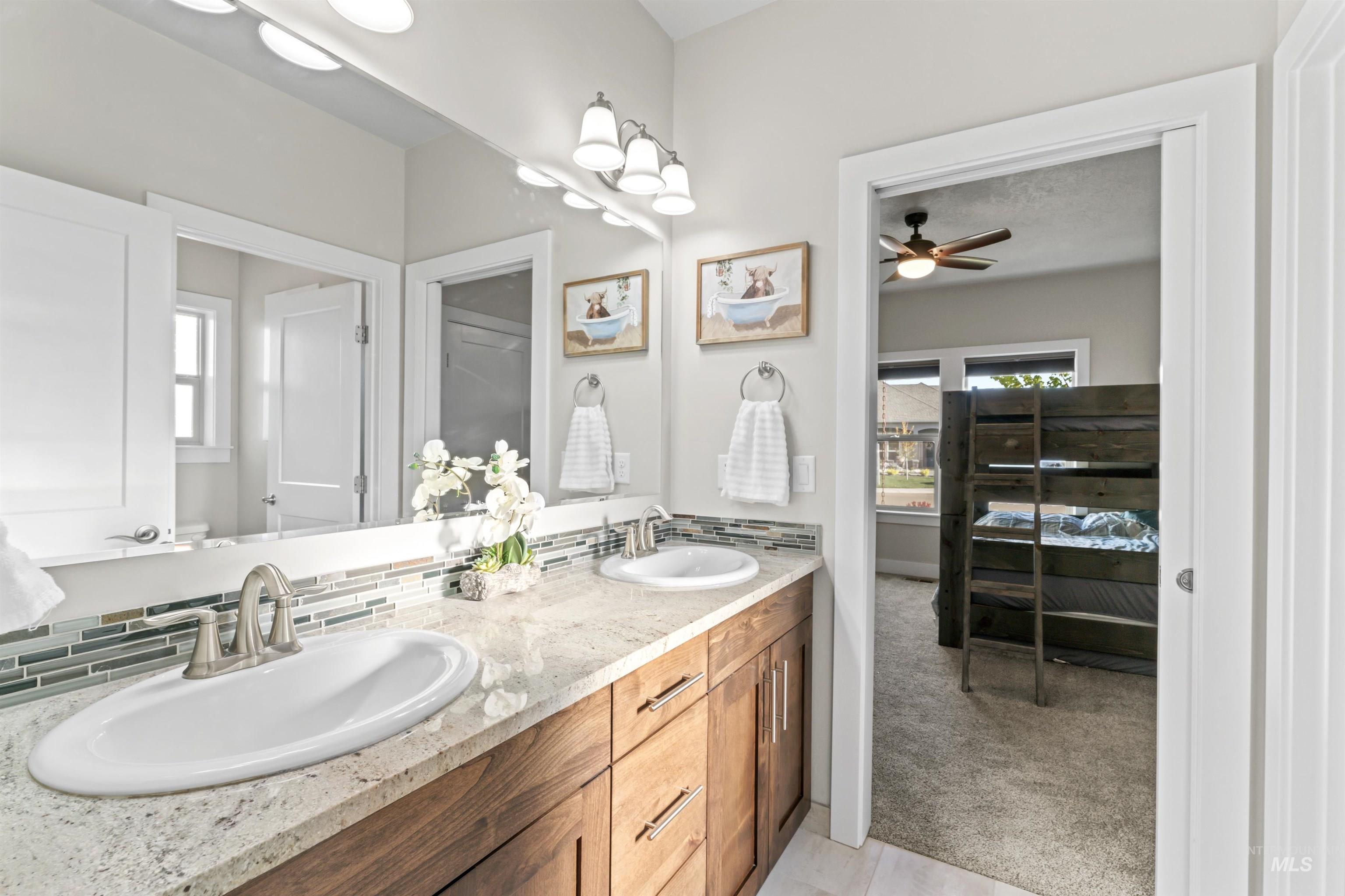 Bathroom with light colored carpet, double vanity, ceiling fan, and light tile patterned floors