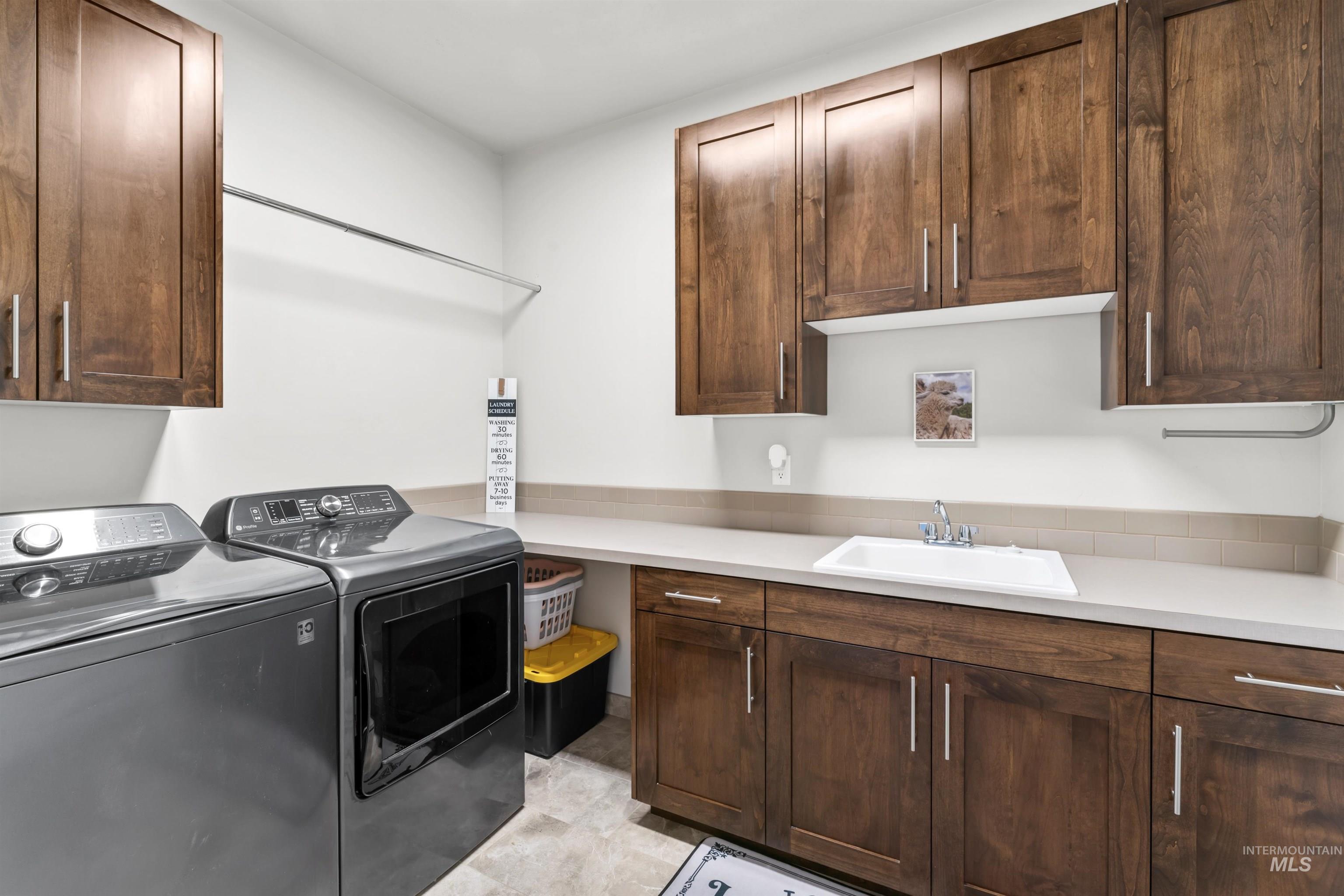 Laundry area featuring cabinet space and separate washer and dryer