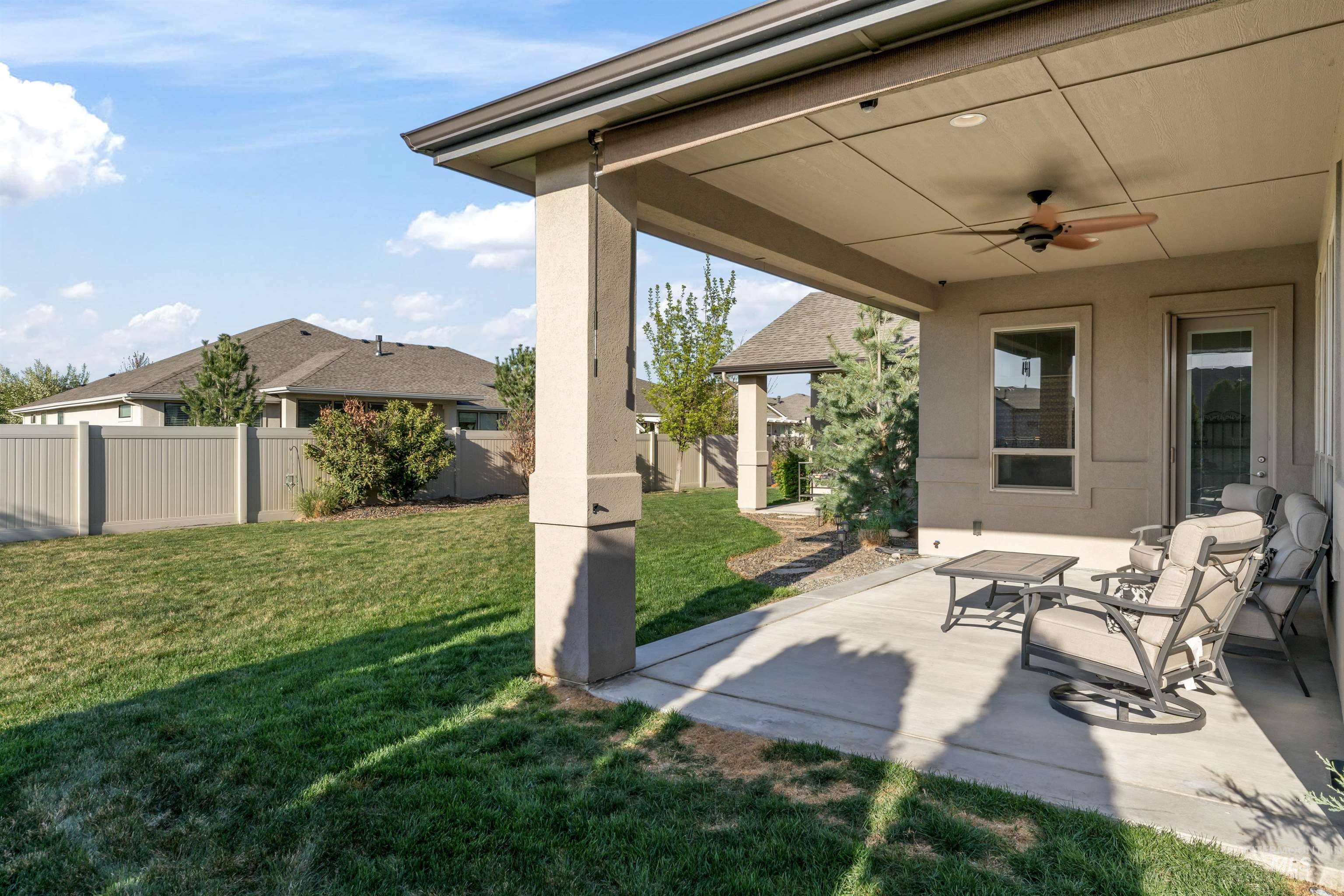 Fenced backyard with ceiling fan and a patio area