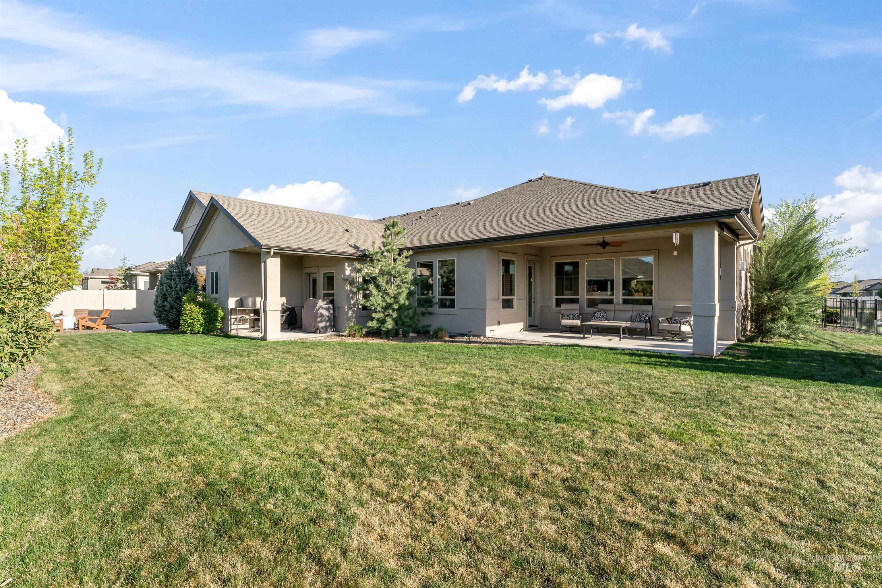 Rear view of house with a patio, stucco siding, a ceiling fan, and roof with shingles