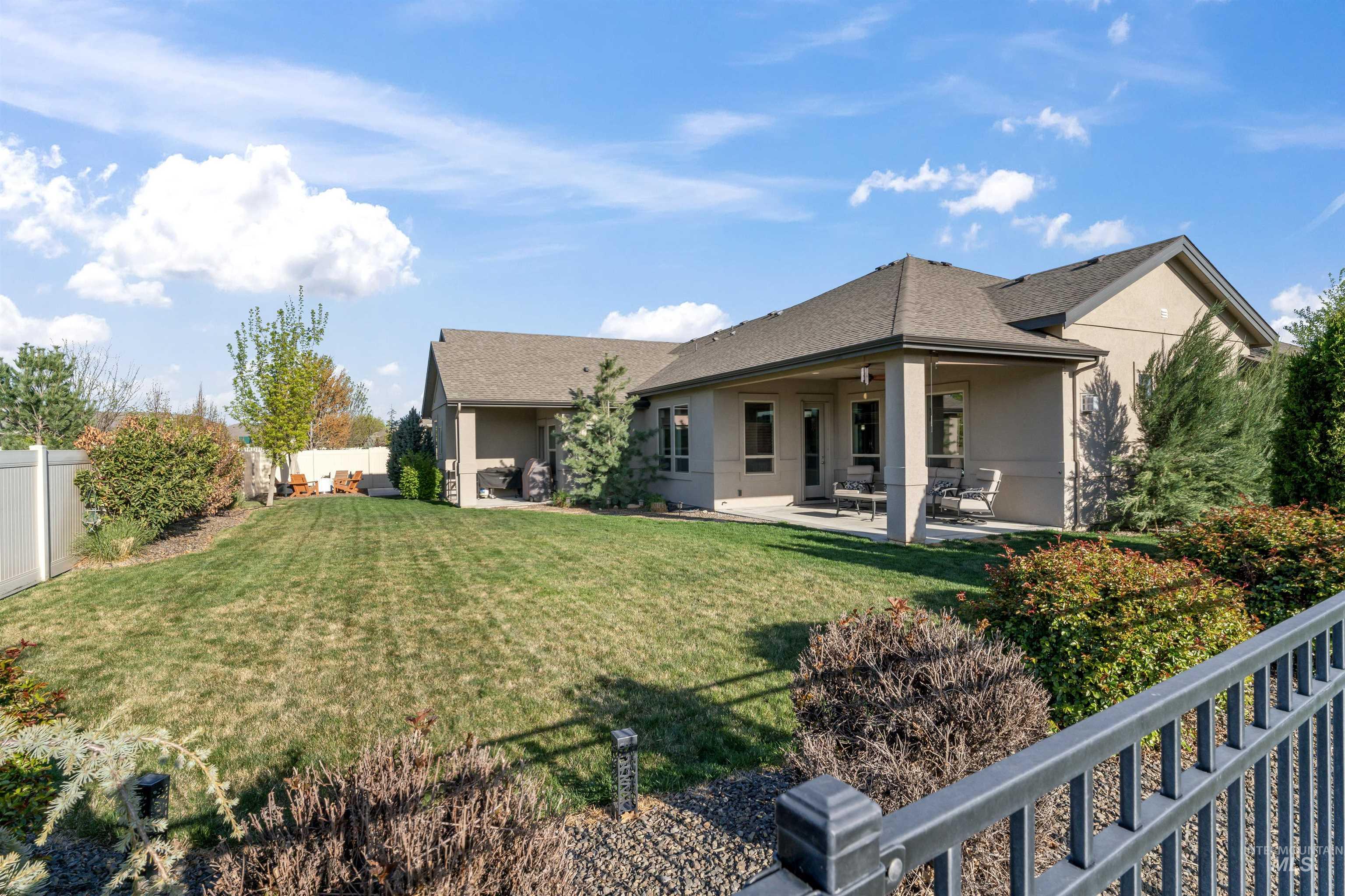 Back of property with a fenced backyard, stucco siding, a patio area, and a shingled roof