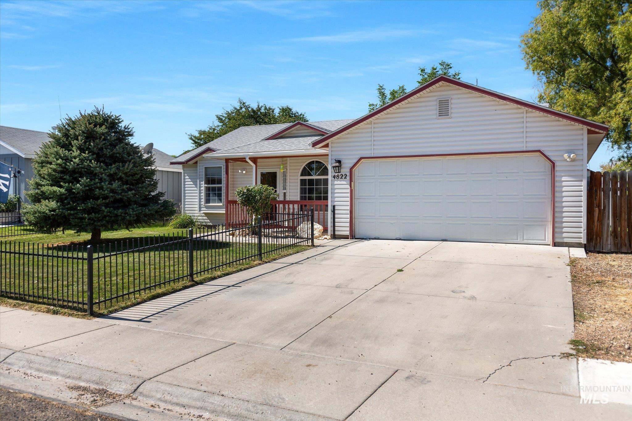 Ranch-style house featuring a fenced front yard, driveway, and a garage
