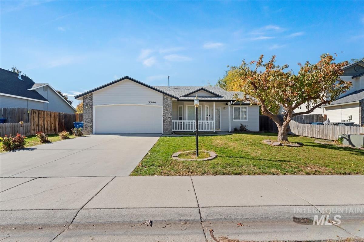 Ranch-style home featuring a porch, driveway, and an attached garage