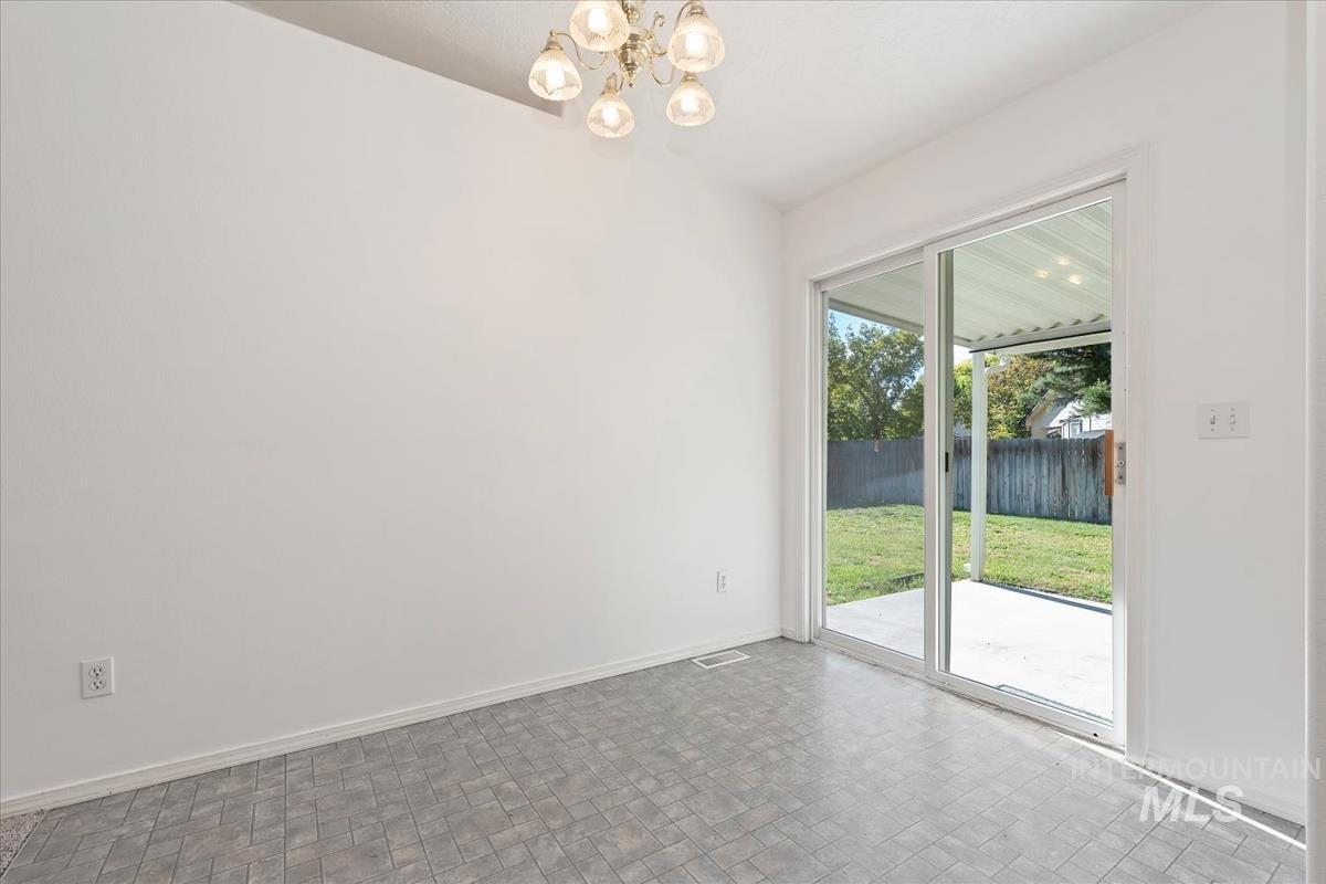 Unfurnished dining area with a chandelier and brick patterned floors