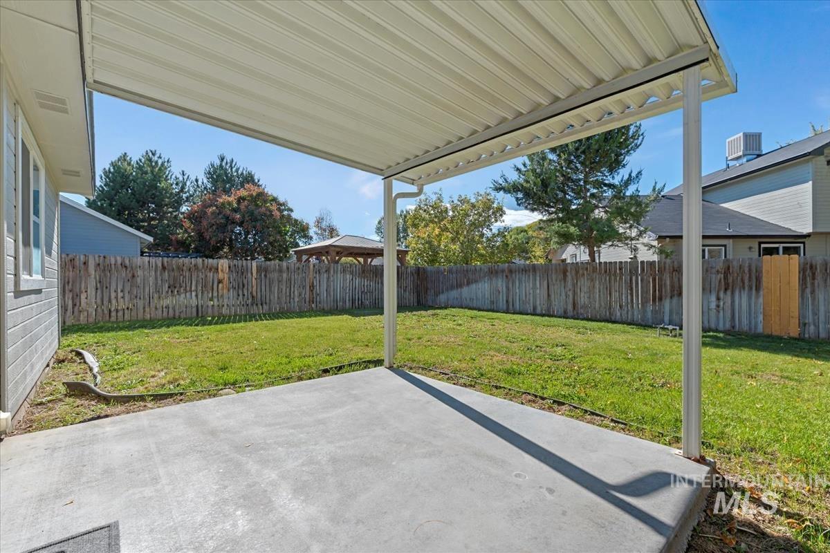 Fenced backyard featuring a patio area and a gazebo