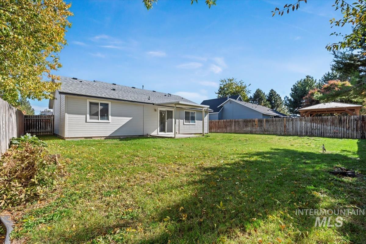 Rear view of house featuring a patio and a fenced backyard
