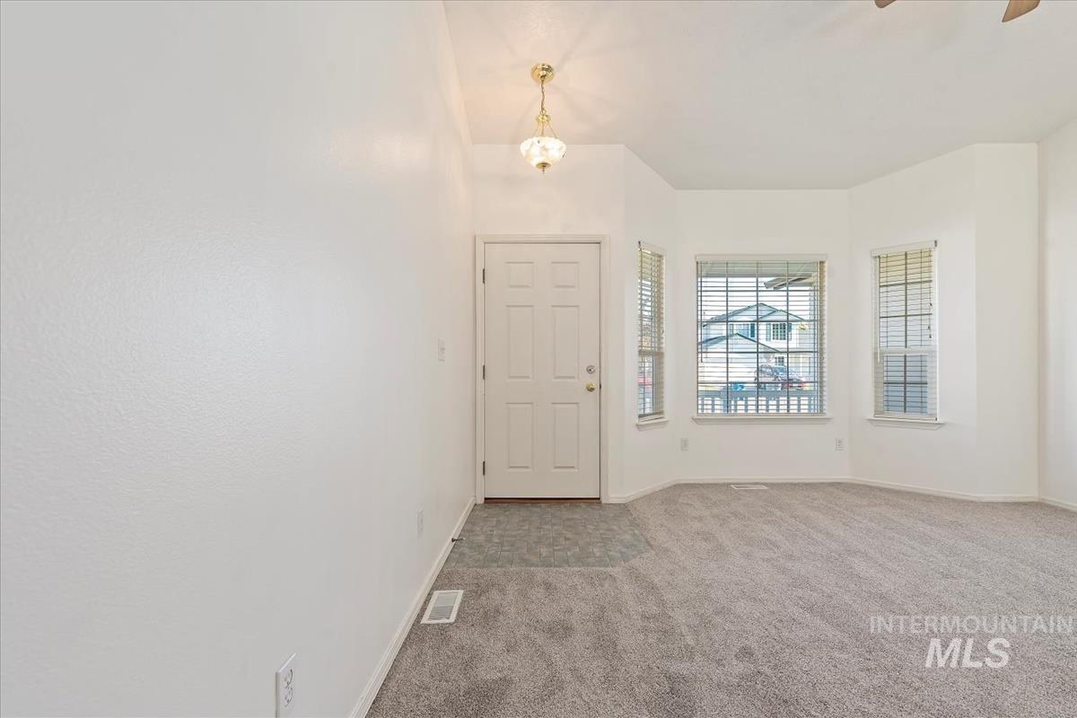 Carpeted entryway with baseboards