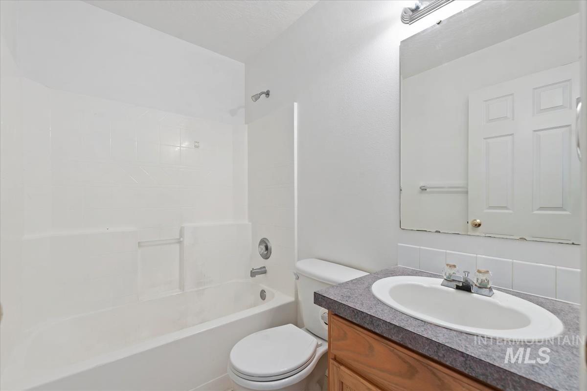 Full bathroom with vanity, tub / shower combination, and tasteful backsplash