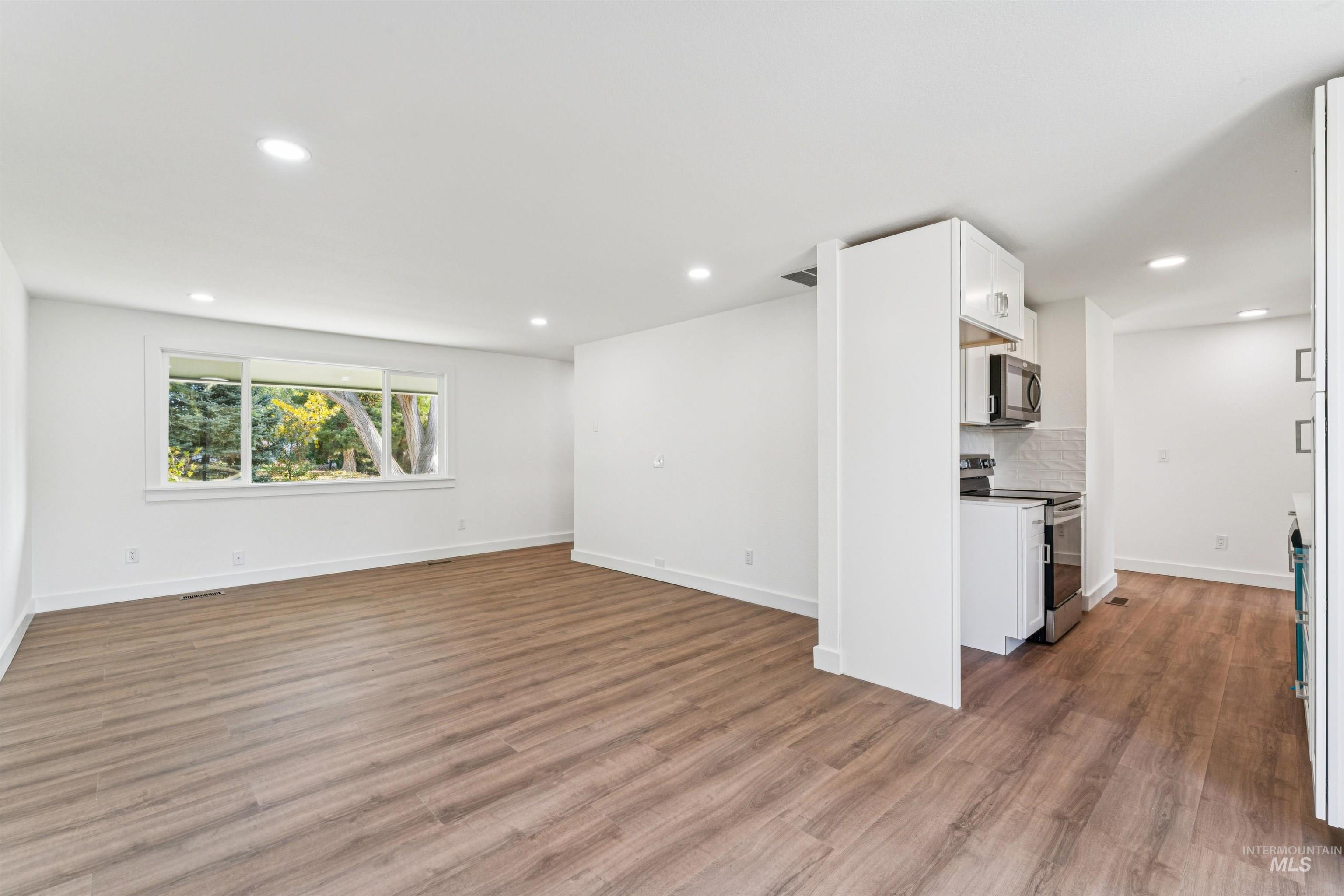 Unfurnished living room featuring light wood-type flooring and recessed lighting