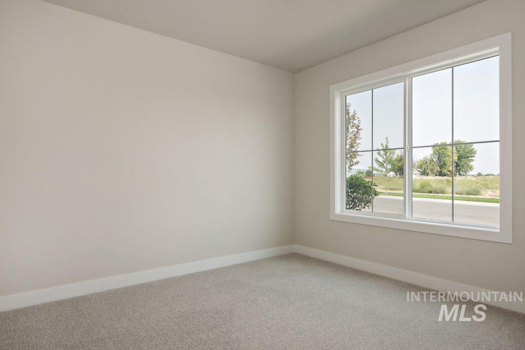 Spare room featuring baseboards and light colored carpet