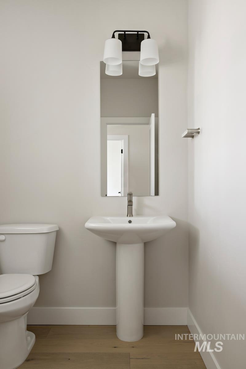 Half bathroom with baseboards and light wood finished floors