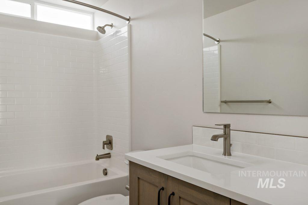 Bathroom featuring vanity and washtub / shower combination