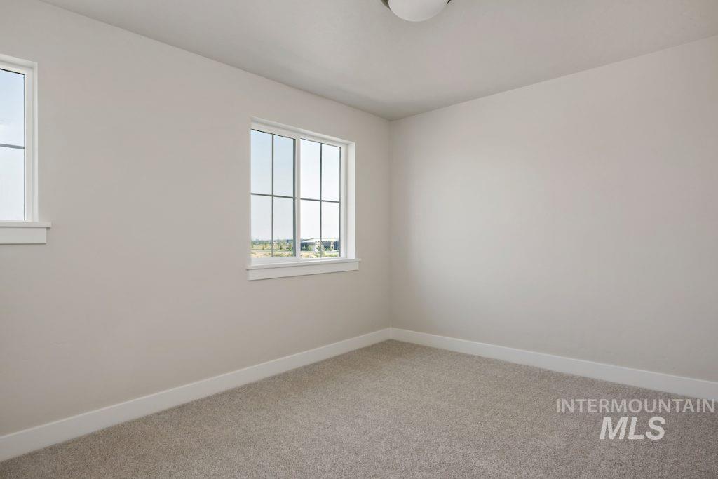 Spare room with baseboards and light carpet