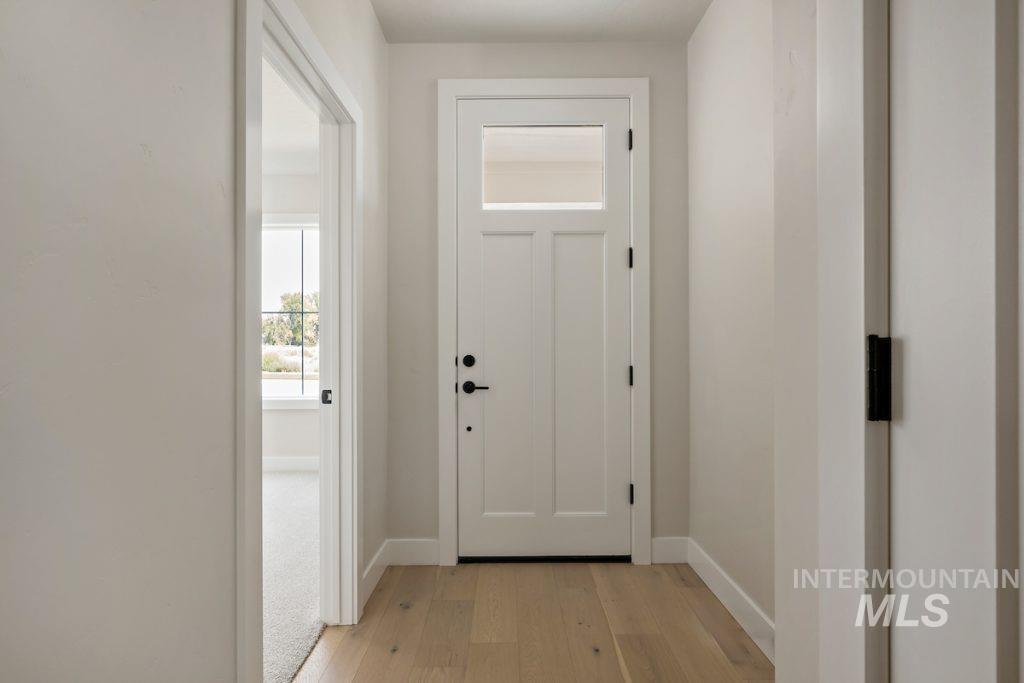 Doorway with baseboards and hardwood / wood-style flooring