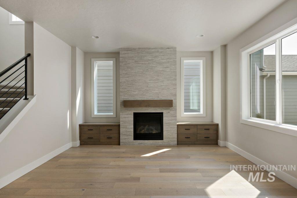 Unfurnished living room with a fireplace and light wood-type flooring