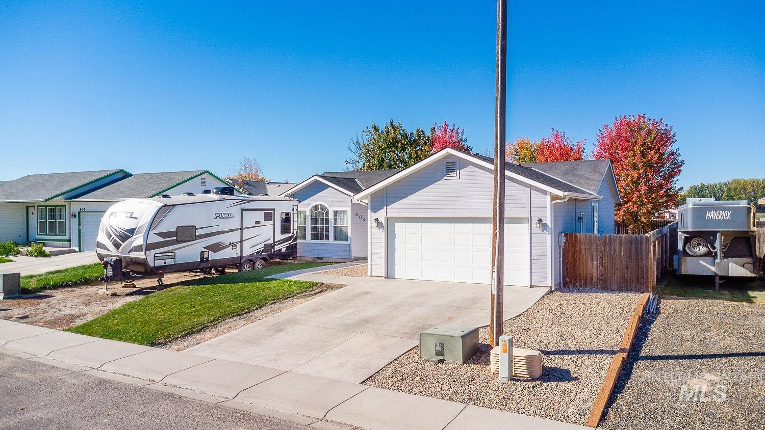Ranch-style home featuring concrete driveway and a garage