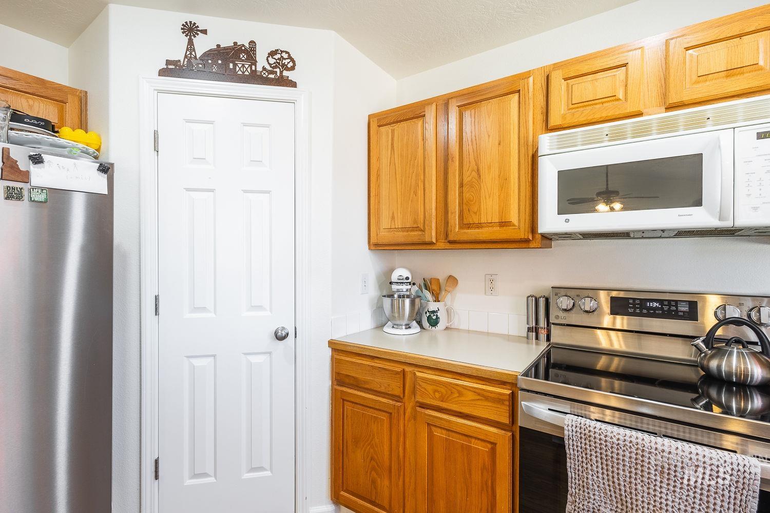 Kitchen featuring appliances with stainless steel finishes, light countertops, and brown cabinets
