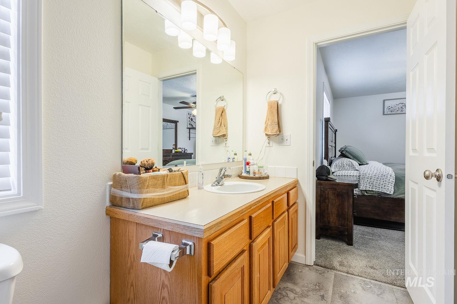 Ensuite bathroom with vanity and ceiling fan