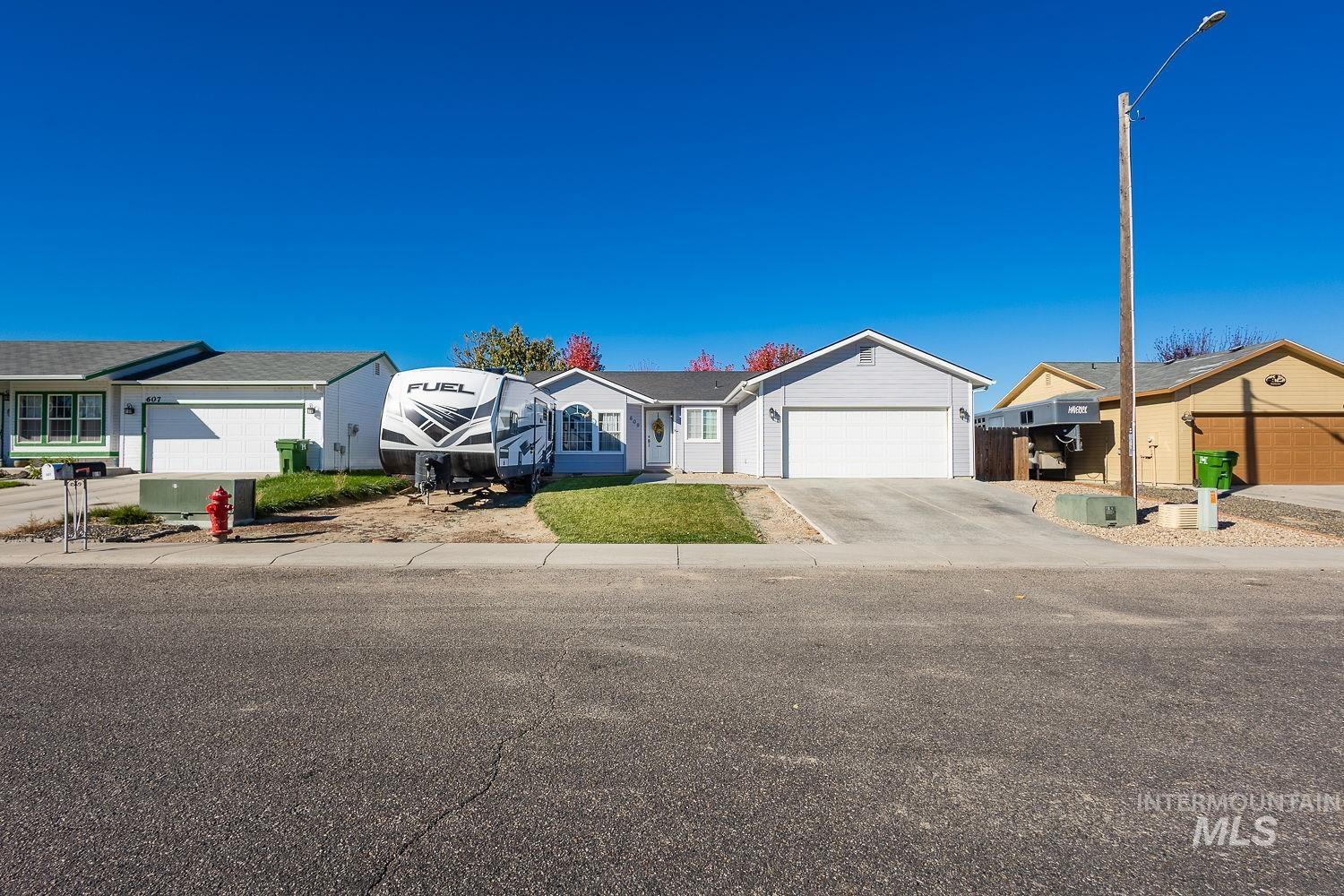 Single story home with concrete driveway, a residential view, and a garage